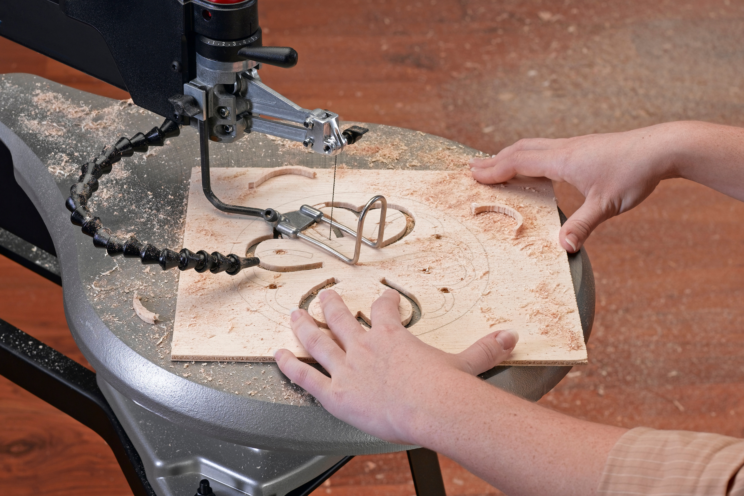 Scroll saw cutting through a piece of wood.