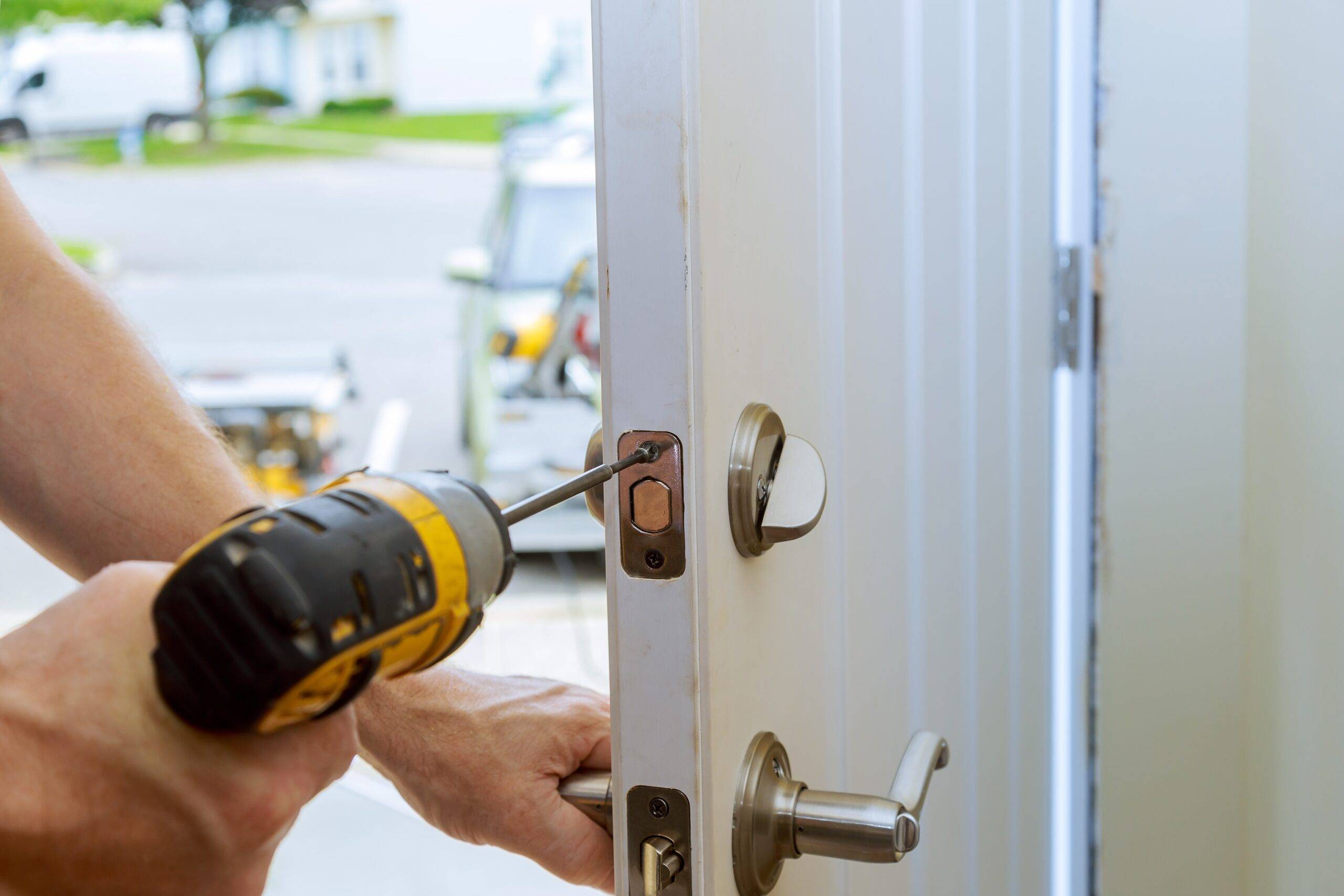 worker's hands installing new door locker man repairing the doorknob. closeup