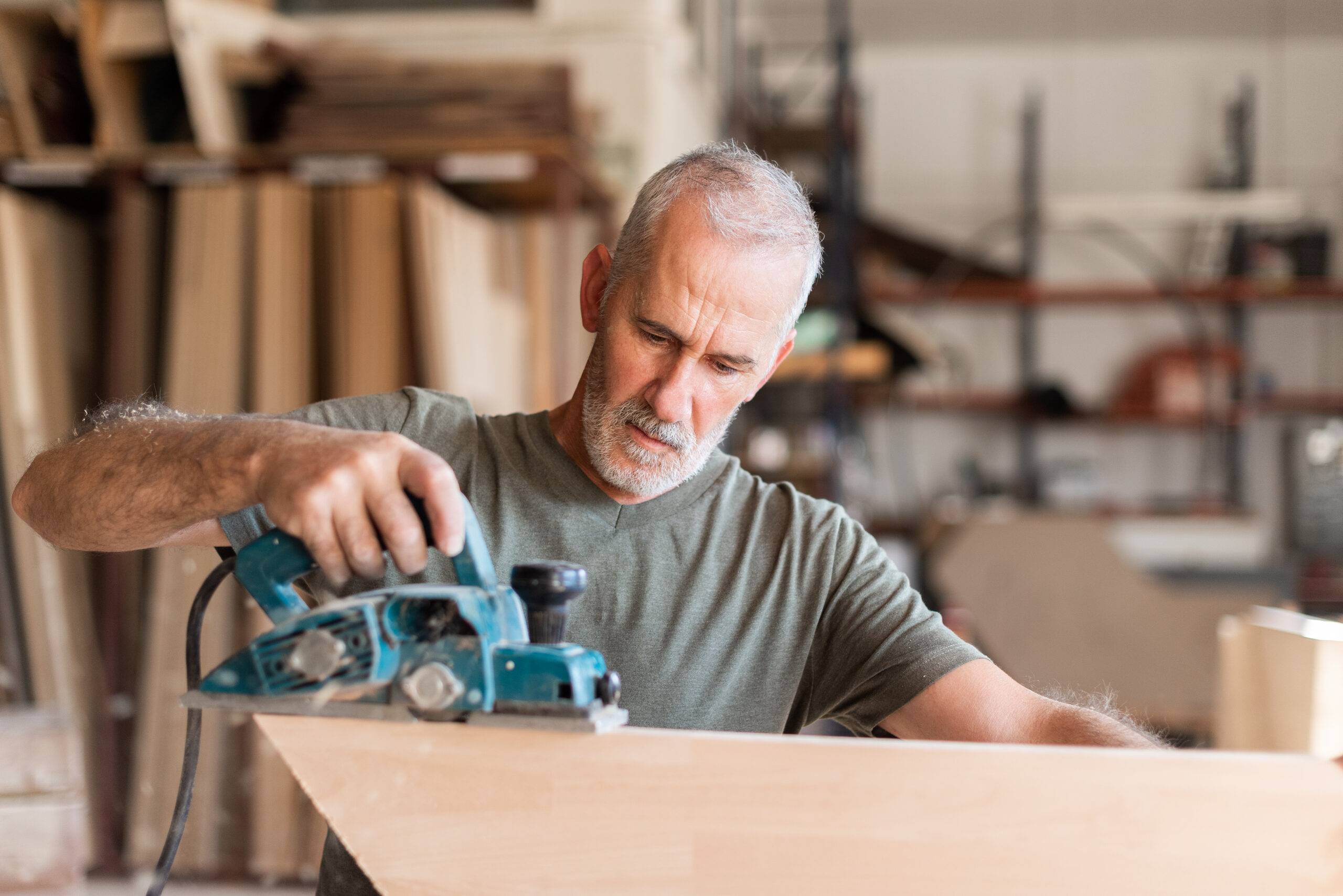 Man planing wood with a hand planer, front view