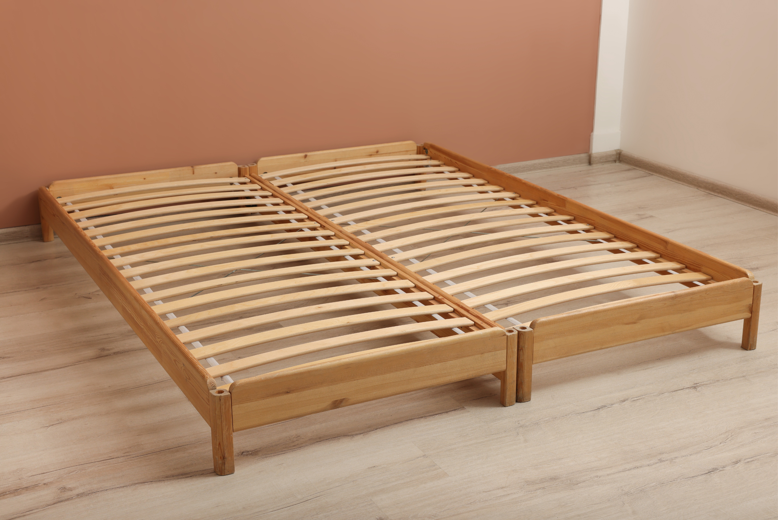 Bare wooden bed frame in an empty room.