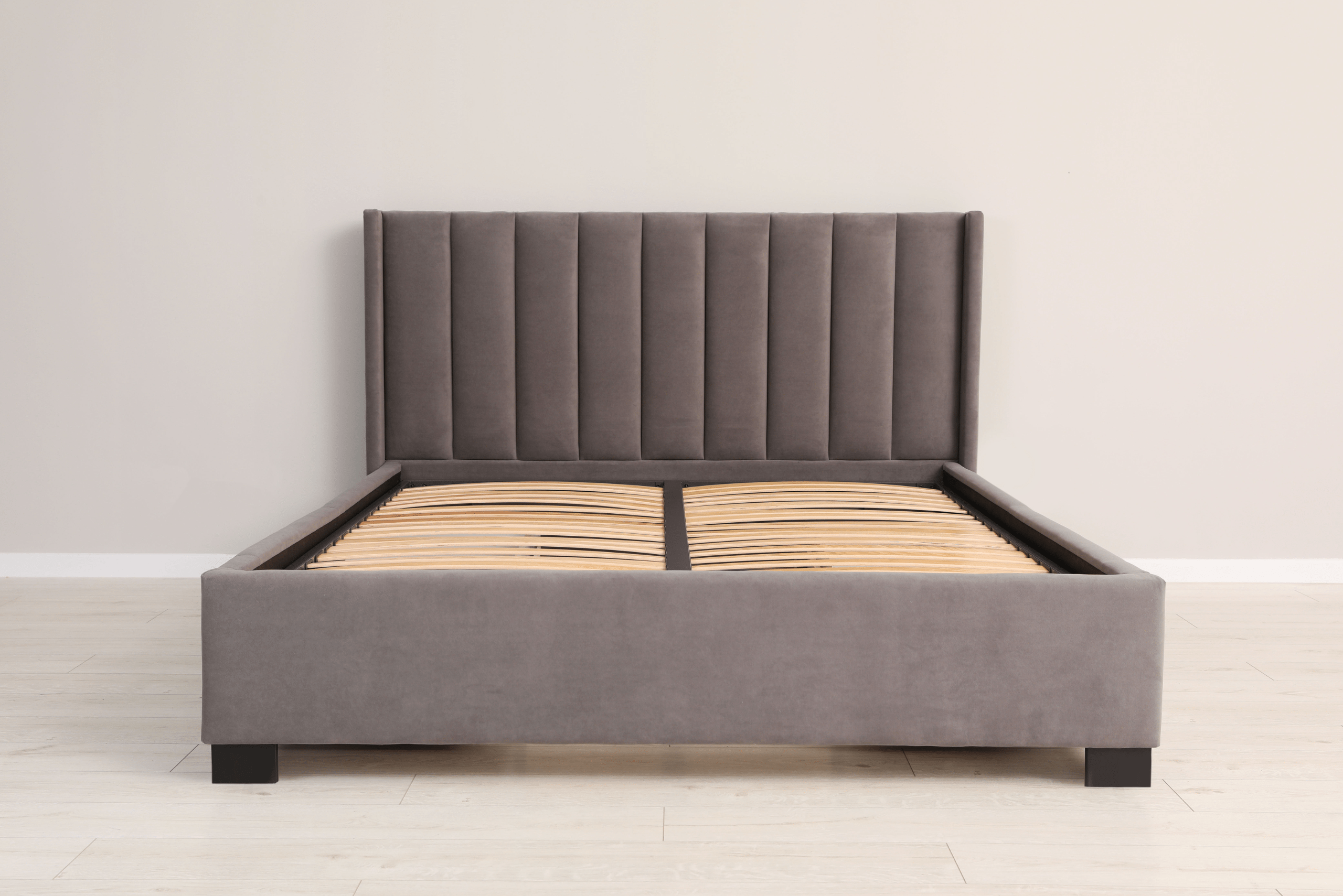 Assembled bed frame with grey fabric finish.