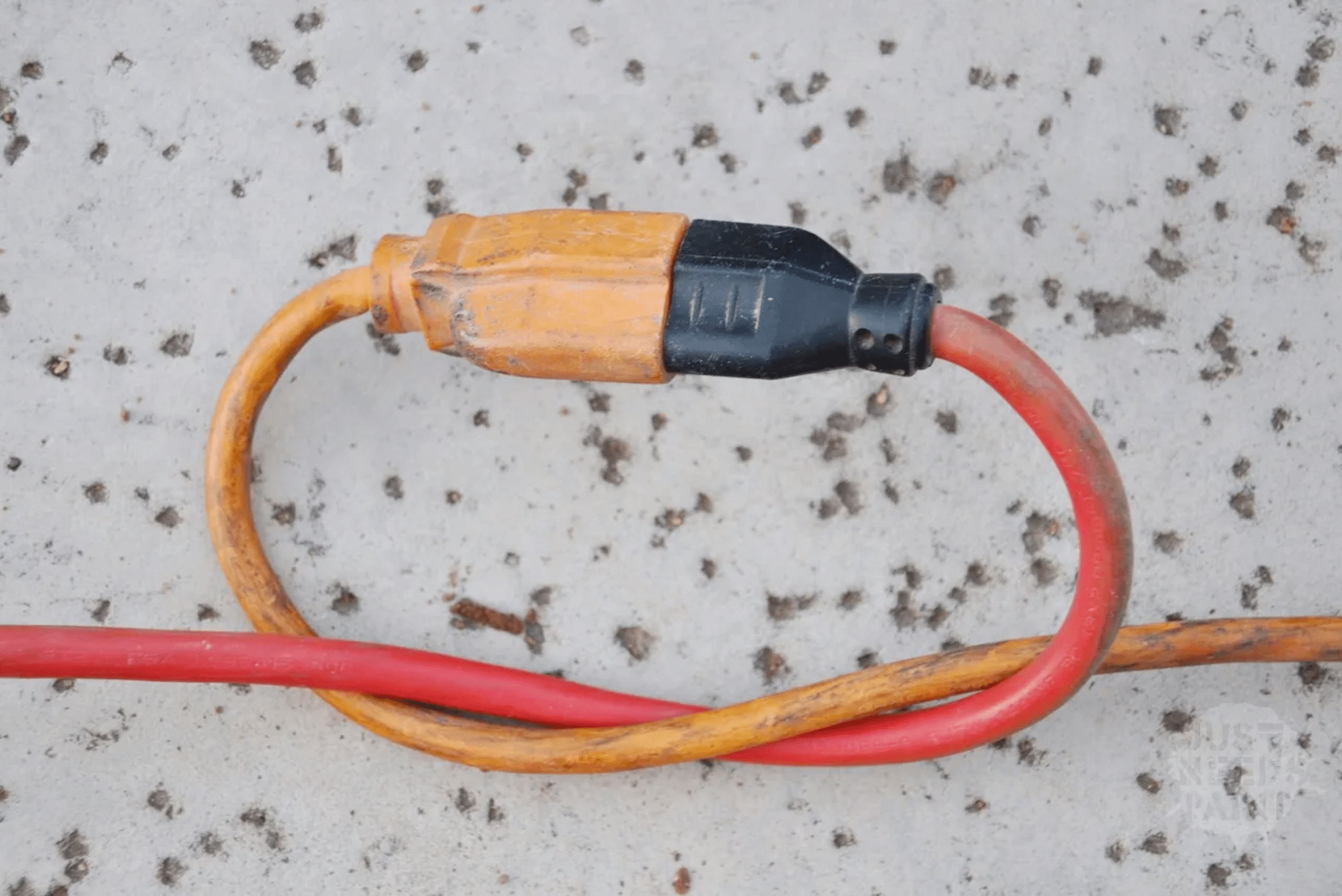 Extension cord and power cord tied together while connected.