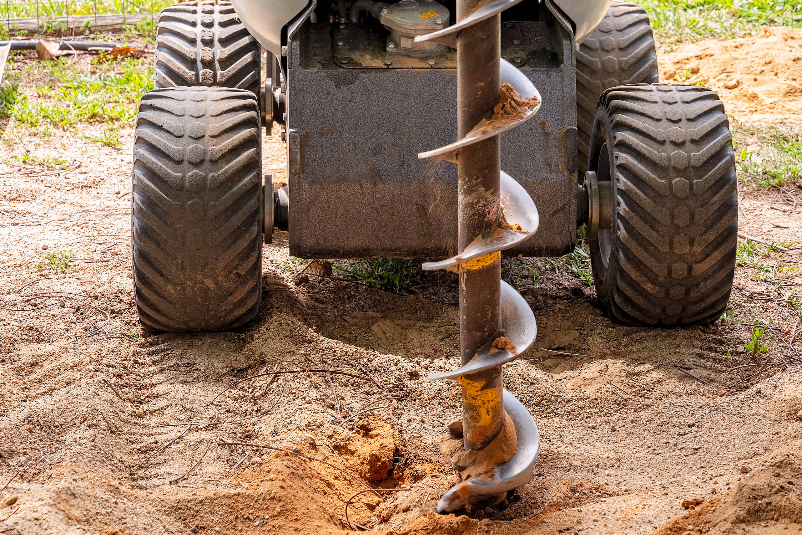 Mechanical post hole digger. 