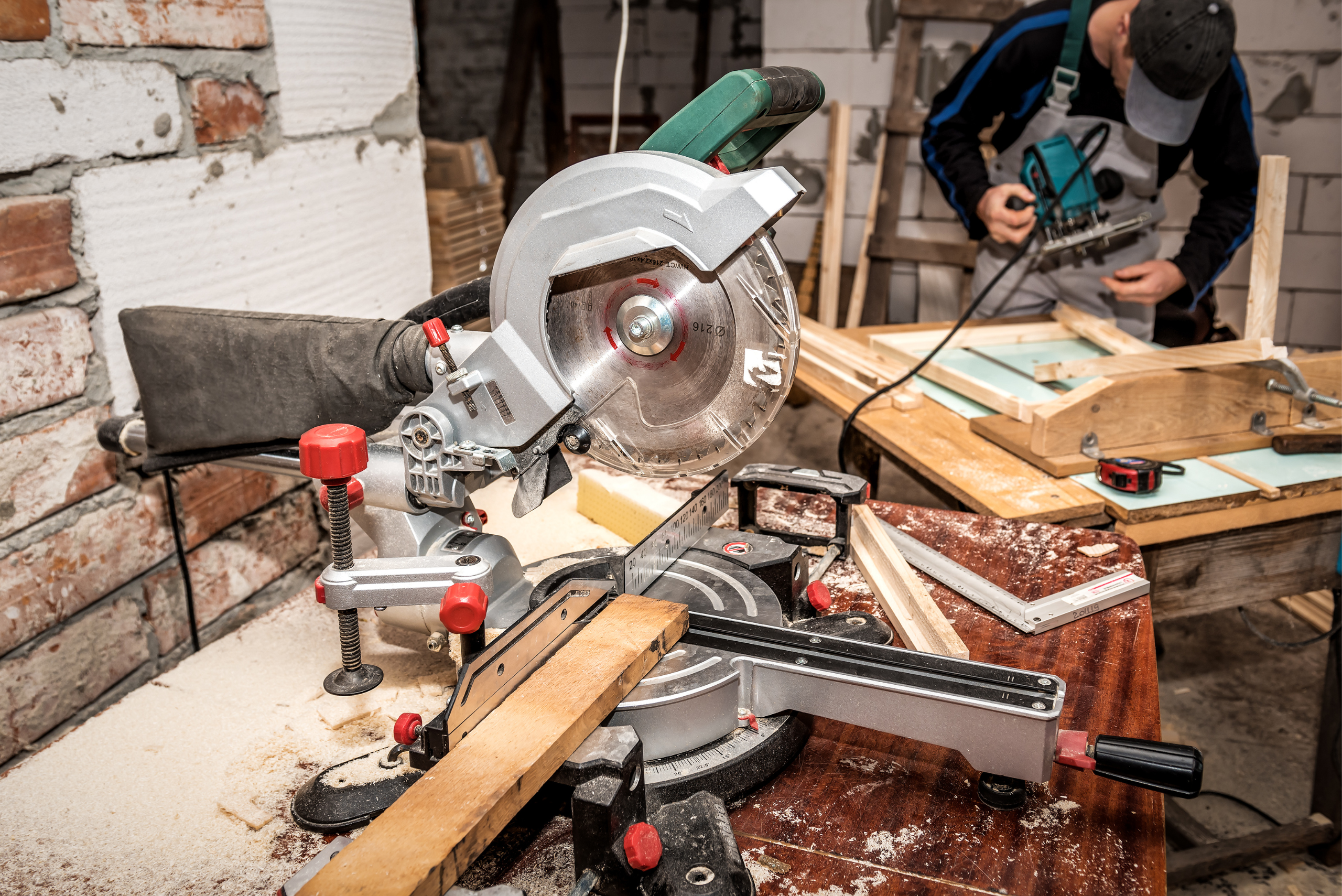 Miter saw in a cluttered work shop.