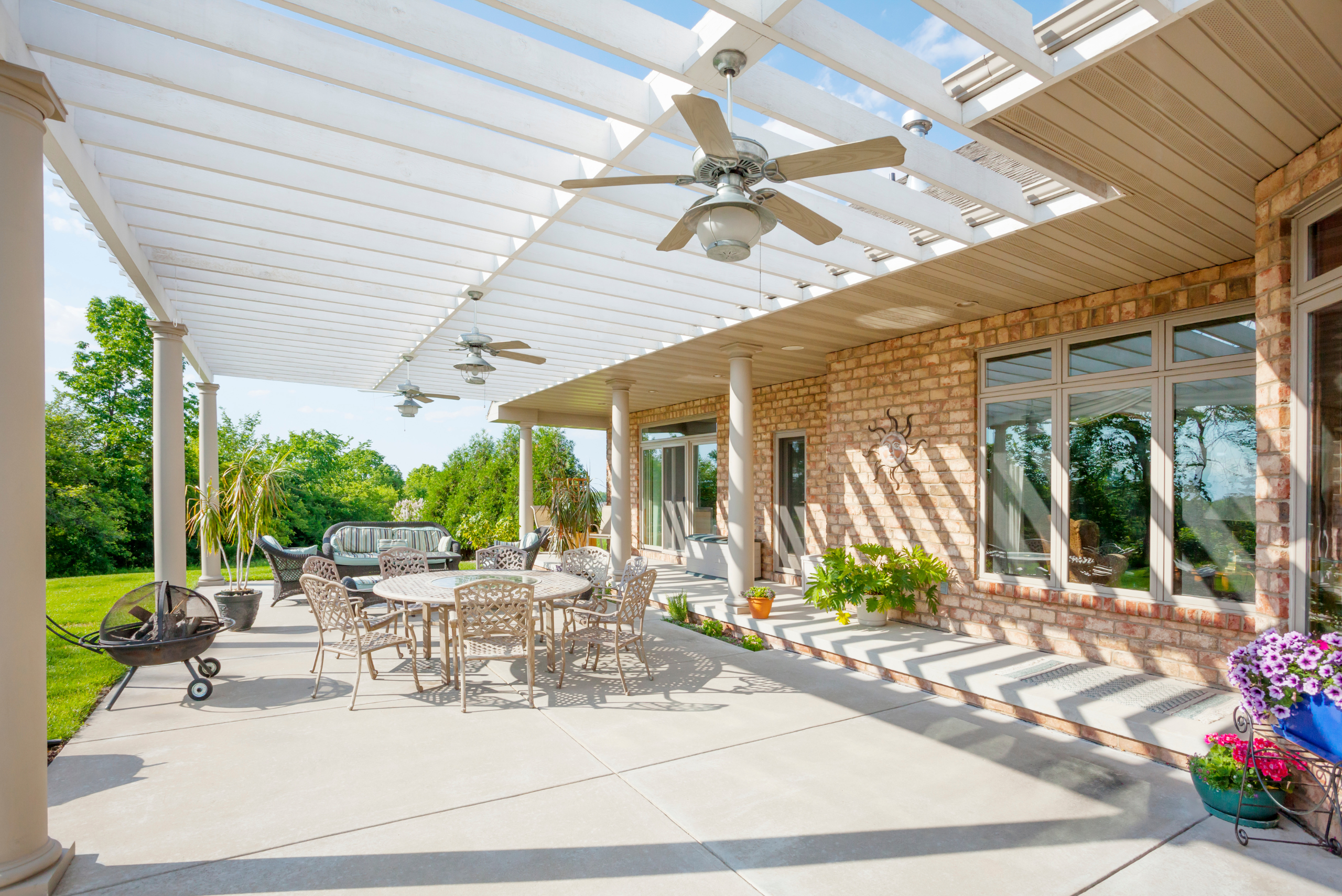 Backyard patio covered by wooden canopy.