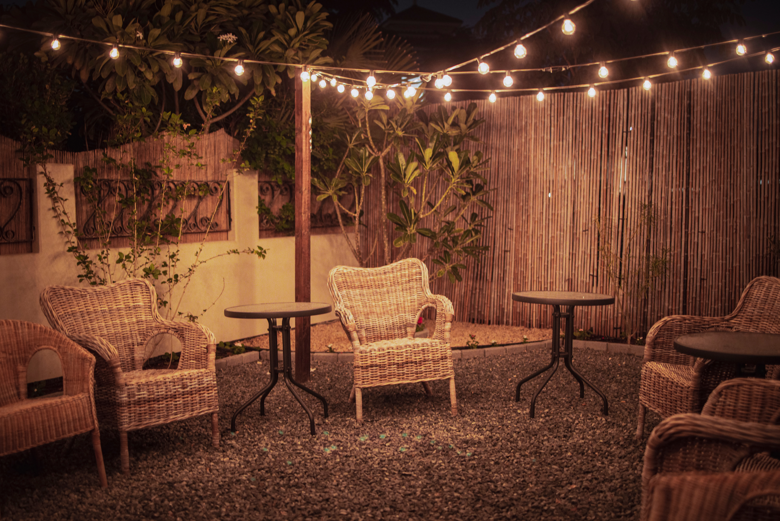 Backyard patio at night lit up by sting lights.