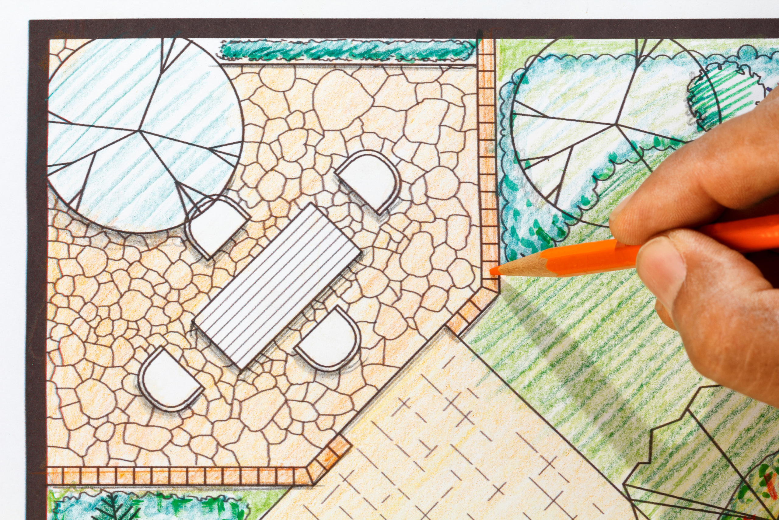 Orange pencil drawing backyard patio plans.