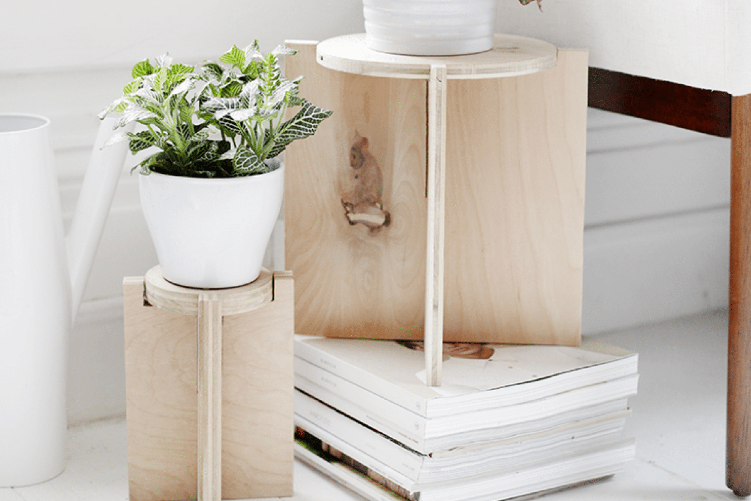 Plant stand made of plywood holding plants in white pots.