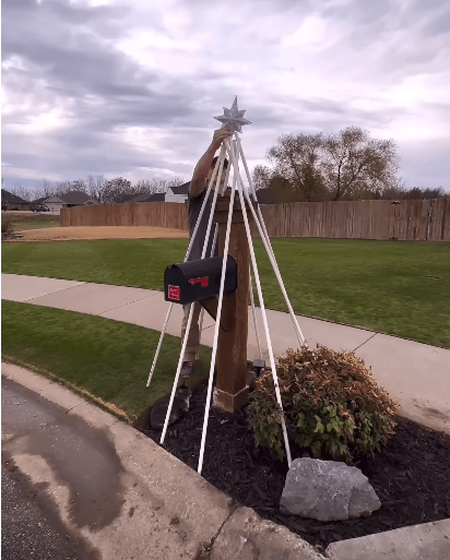 Mailbox surrounded by PCV pipe as frame for Christmas tree.