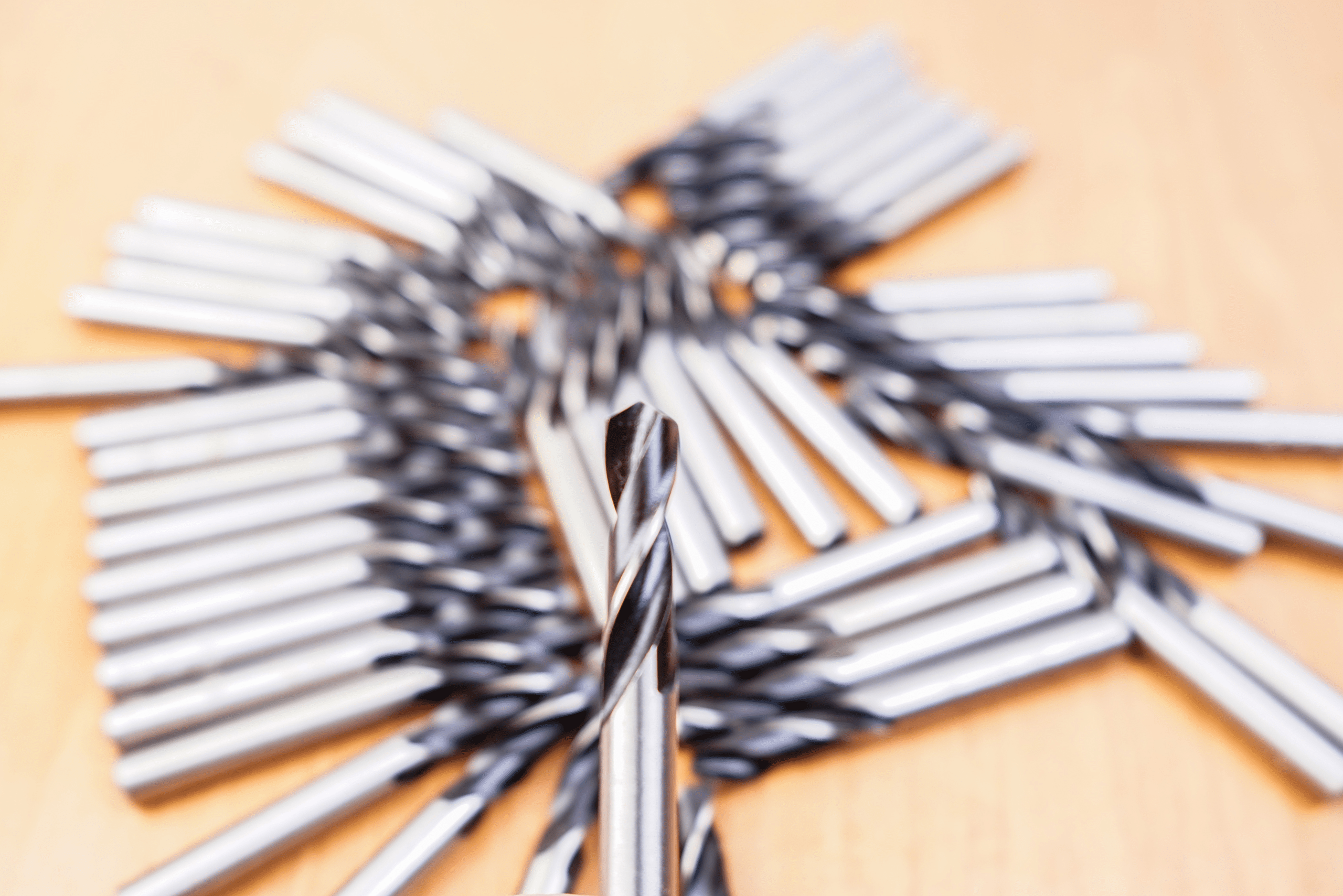 Bunch of drill bits for metal on wooden table.