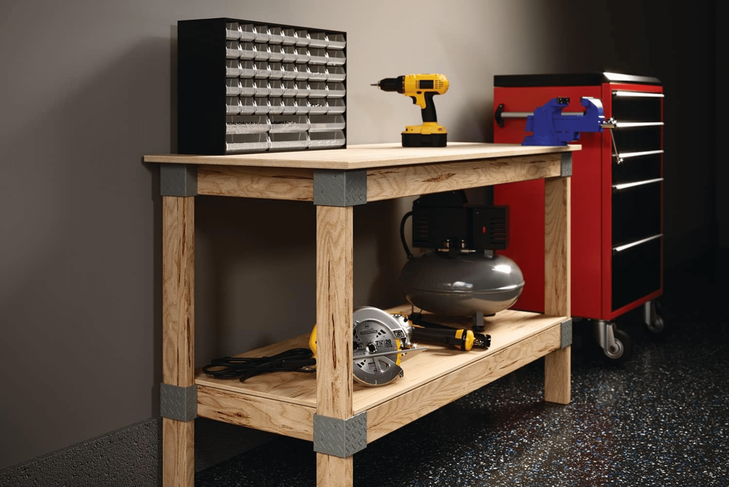 A workbench with a yellow drill and a bolt and nut organizer.