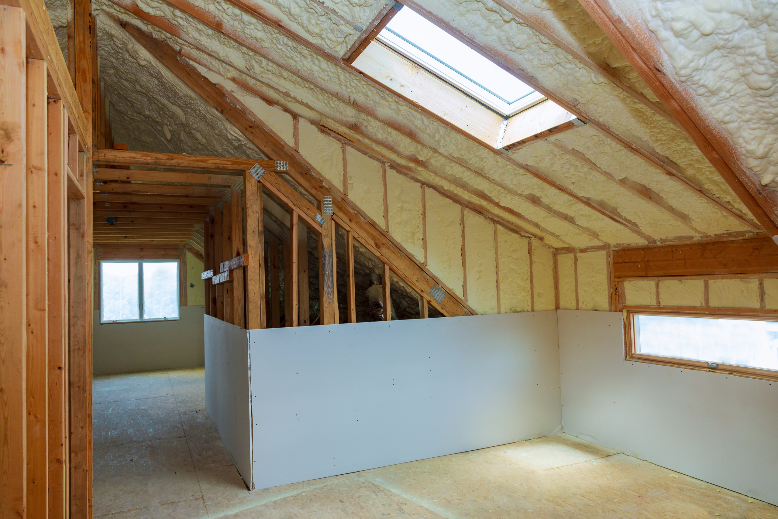 Inside of an unfinished attic with 2x4 boards still exposed.