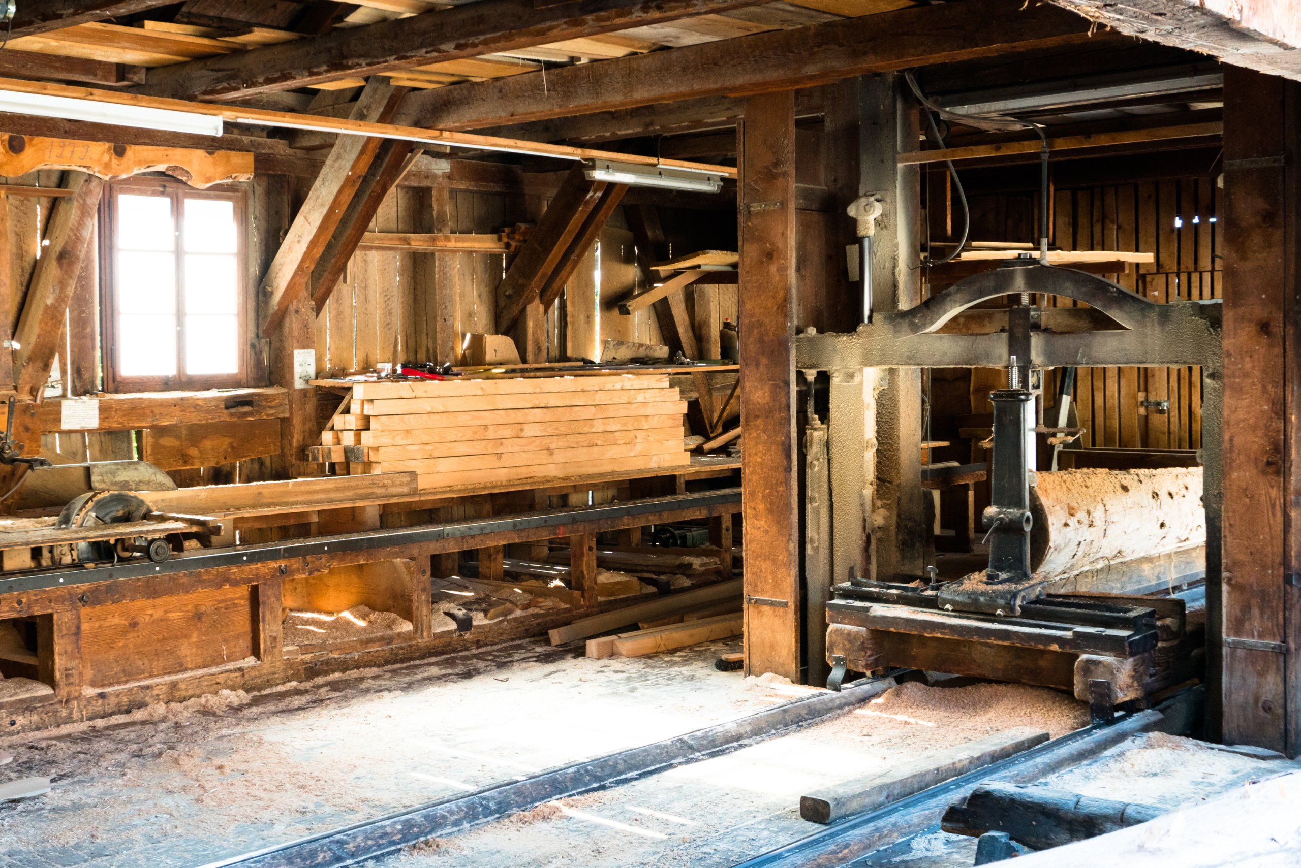 Lumbar mill with unfinished wood and 2x4 board cuts.