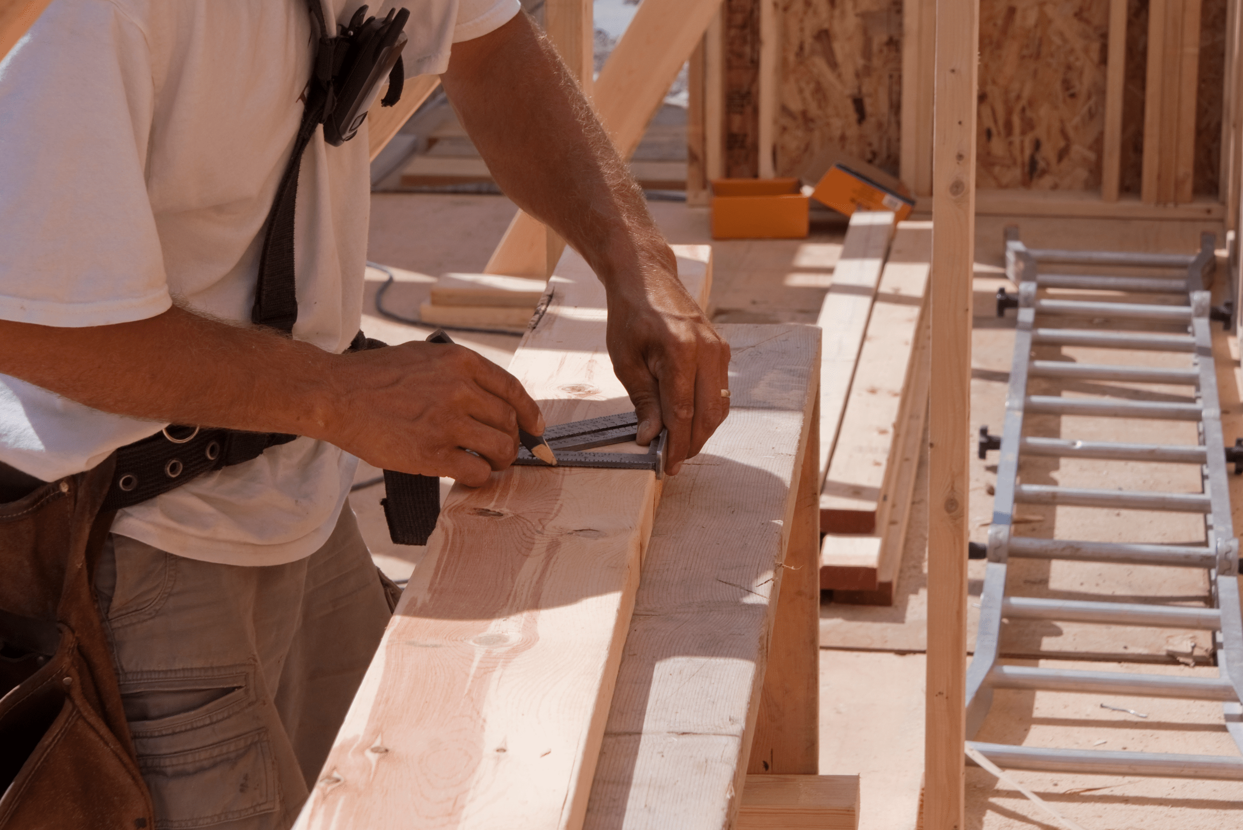 Person measuring a piece of 2x4 wood.