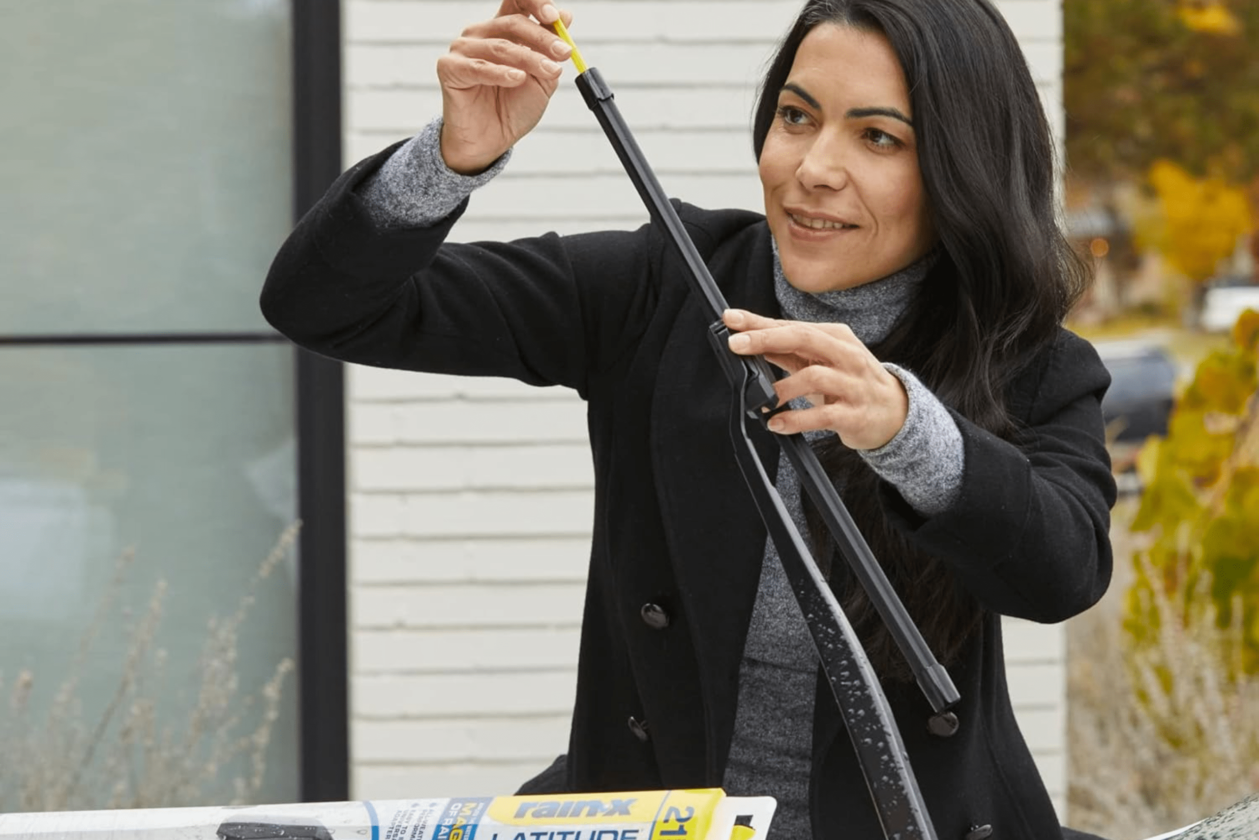 Woman removing protective shipping cover from wiper blade.
