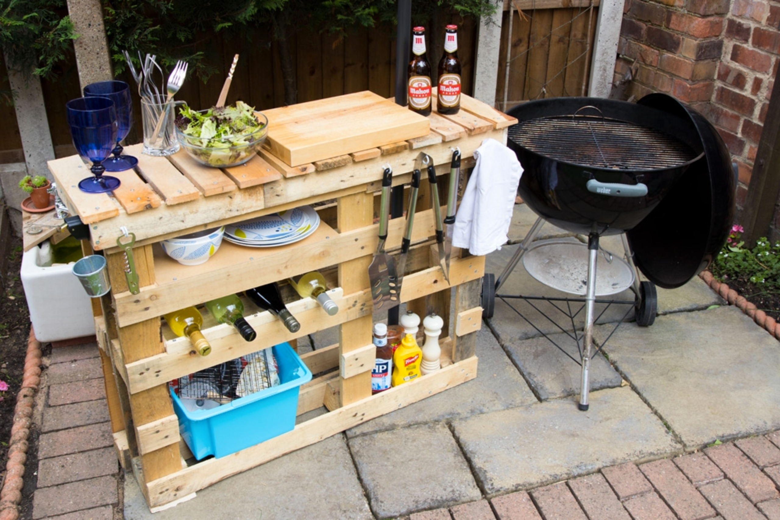 A prep station made of pallets, with a BBQ on the side.