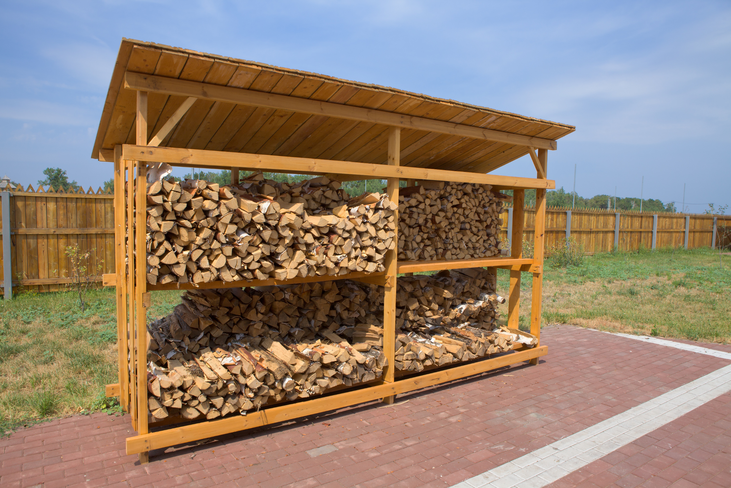 Outdoor DIY firewood rack with shelves and roof.