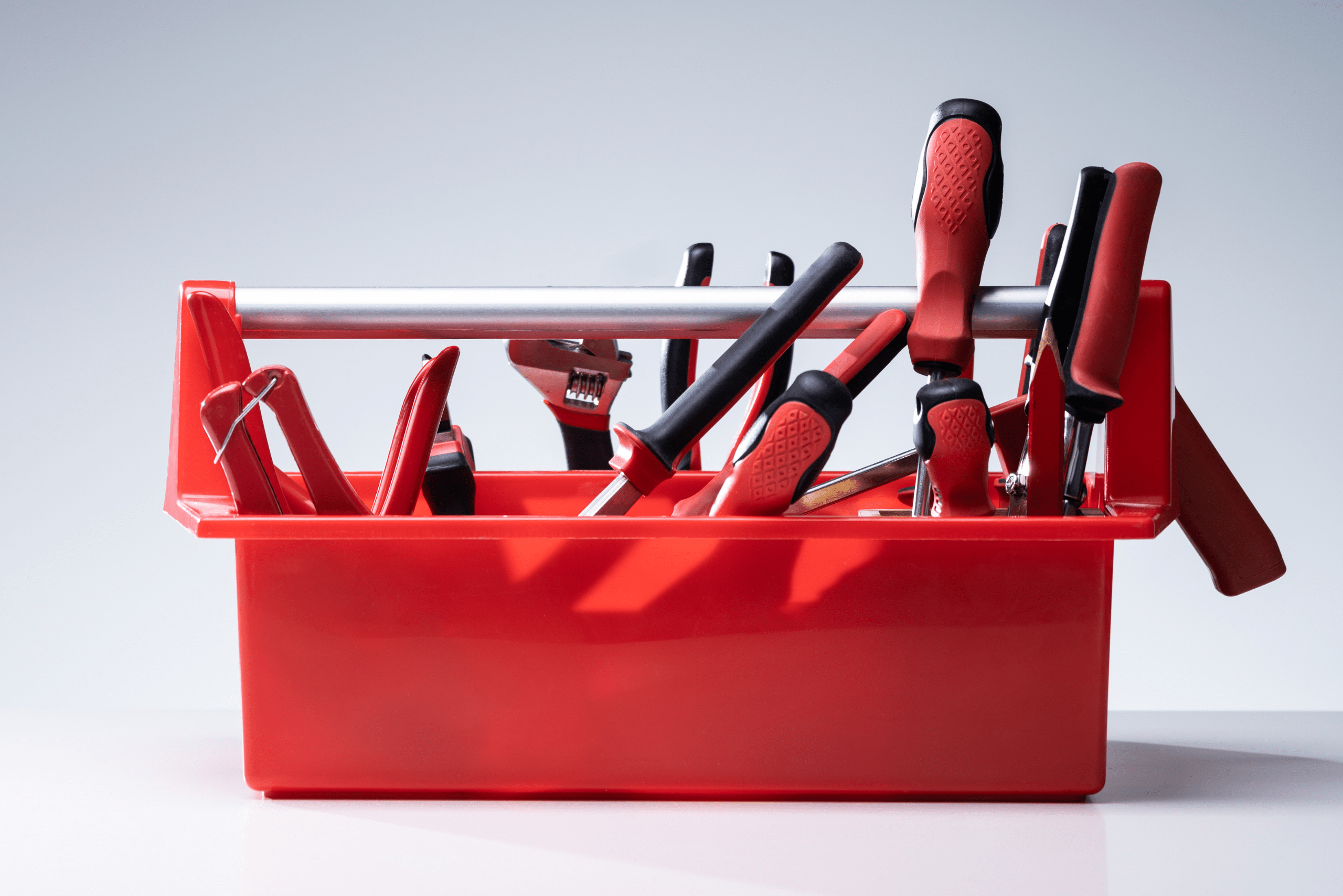 Red tool holder with an assortment of tools.