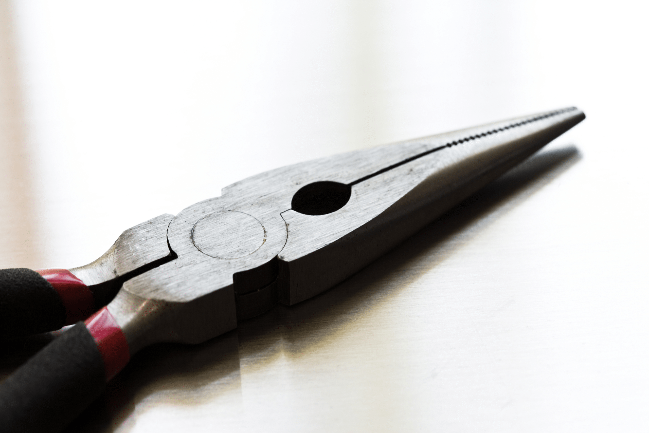 Closeup of pliers on a white background.