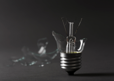 broken light bulb on grey background