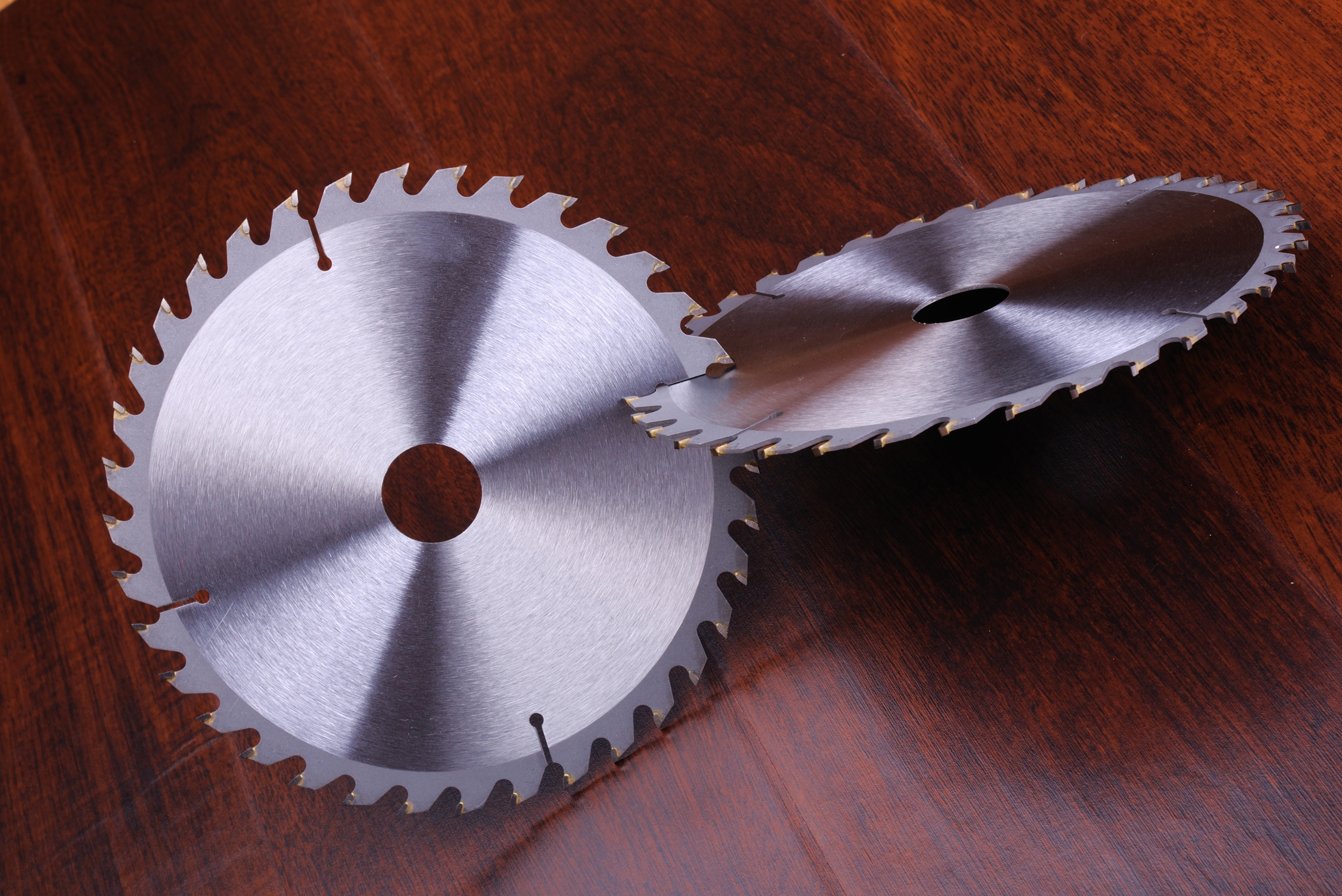 Circular saw cutting blades on a wooden floor.