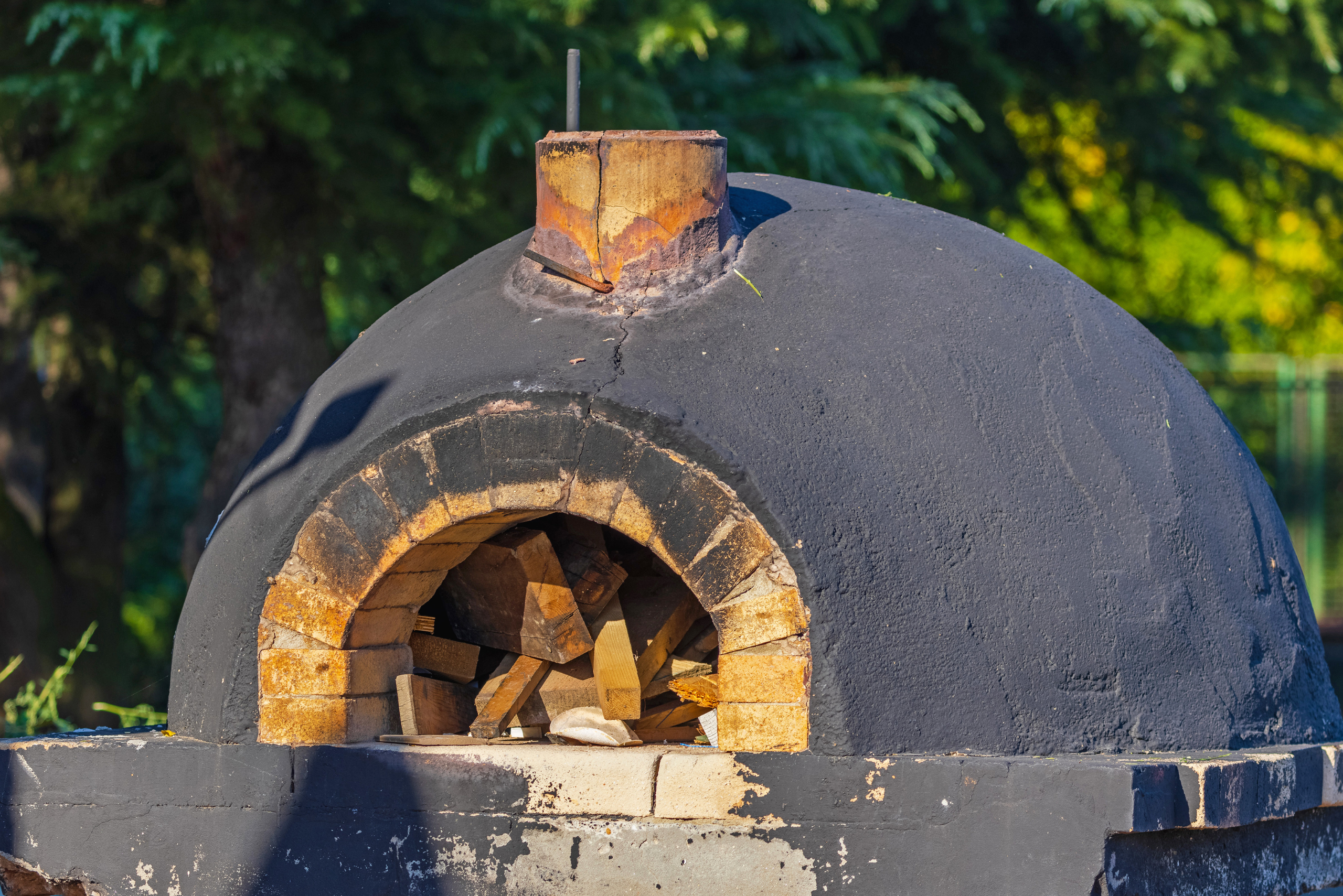Brick outdoor pizza oven covered in cement.