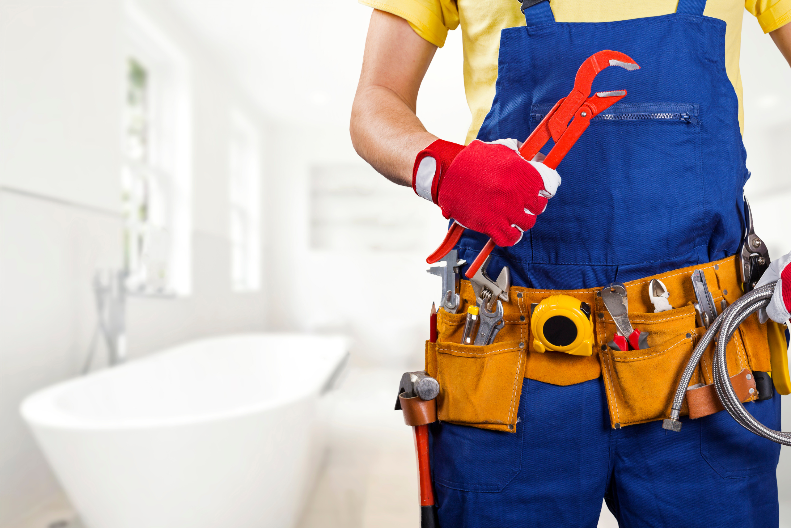Handyman in blue overalls with tool belt.