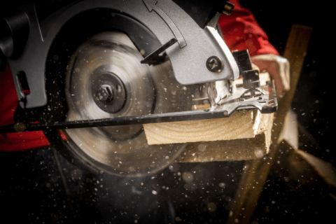 A circular saw making a cut on a wooden board.