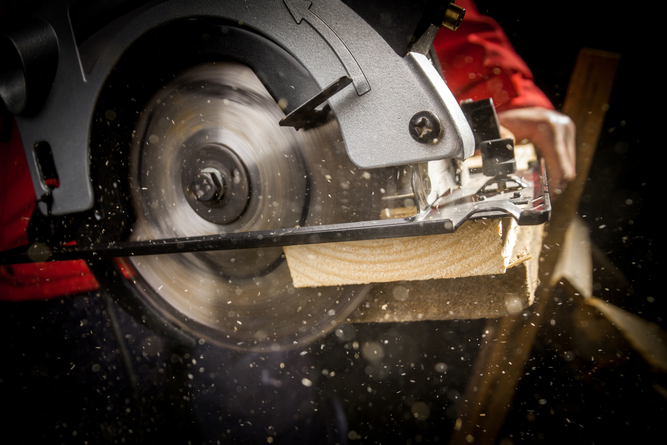 A circular saw making a cut on a wooden board.