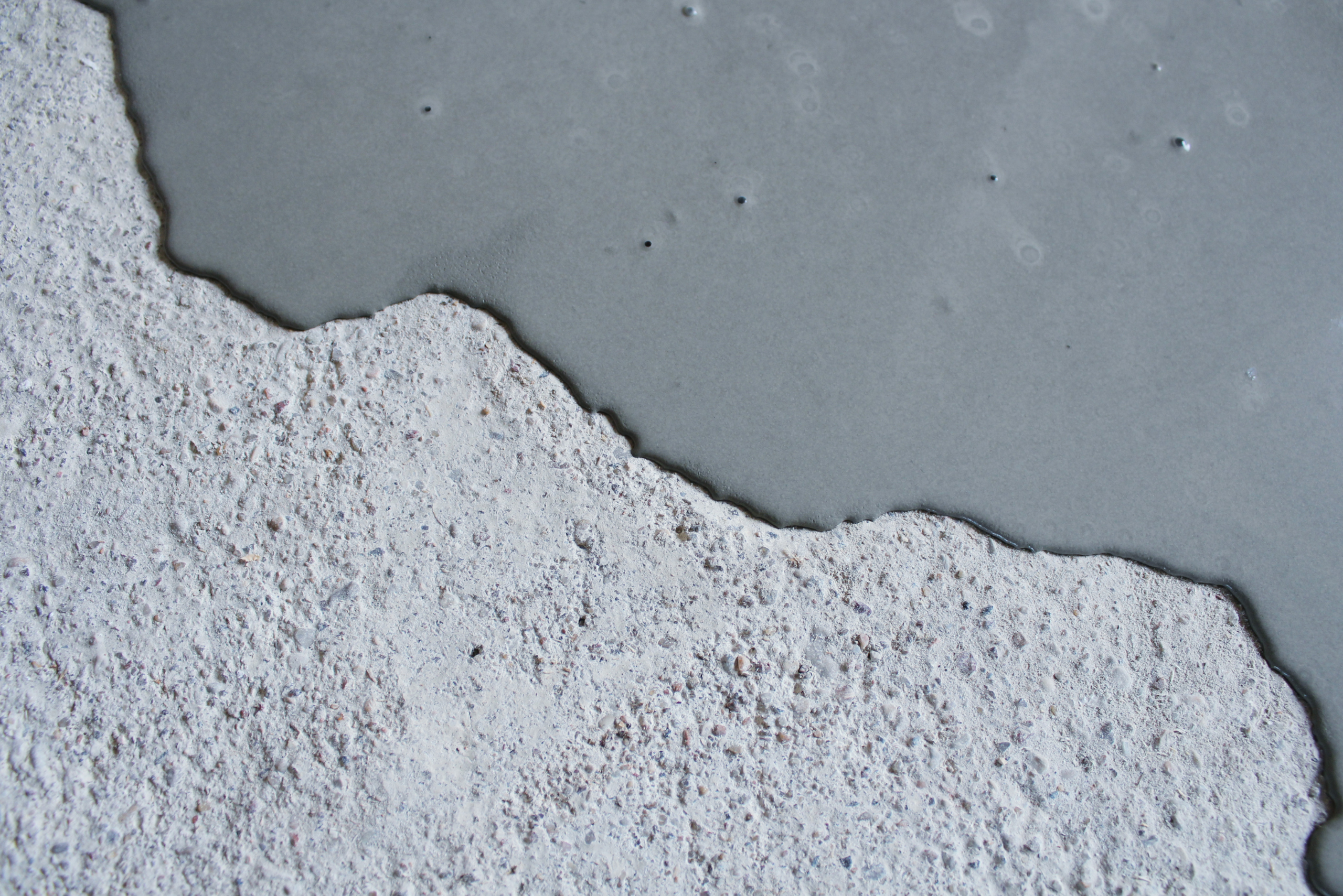 A layer of self-leveling concrete poured on uneven floor.