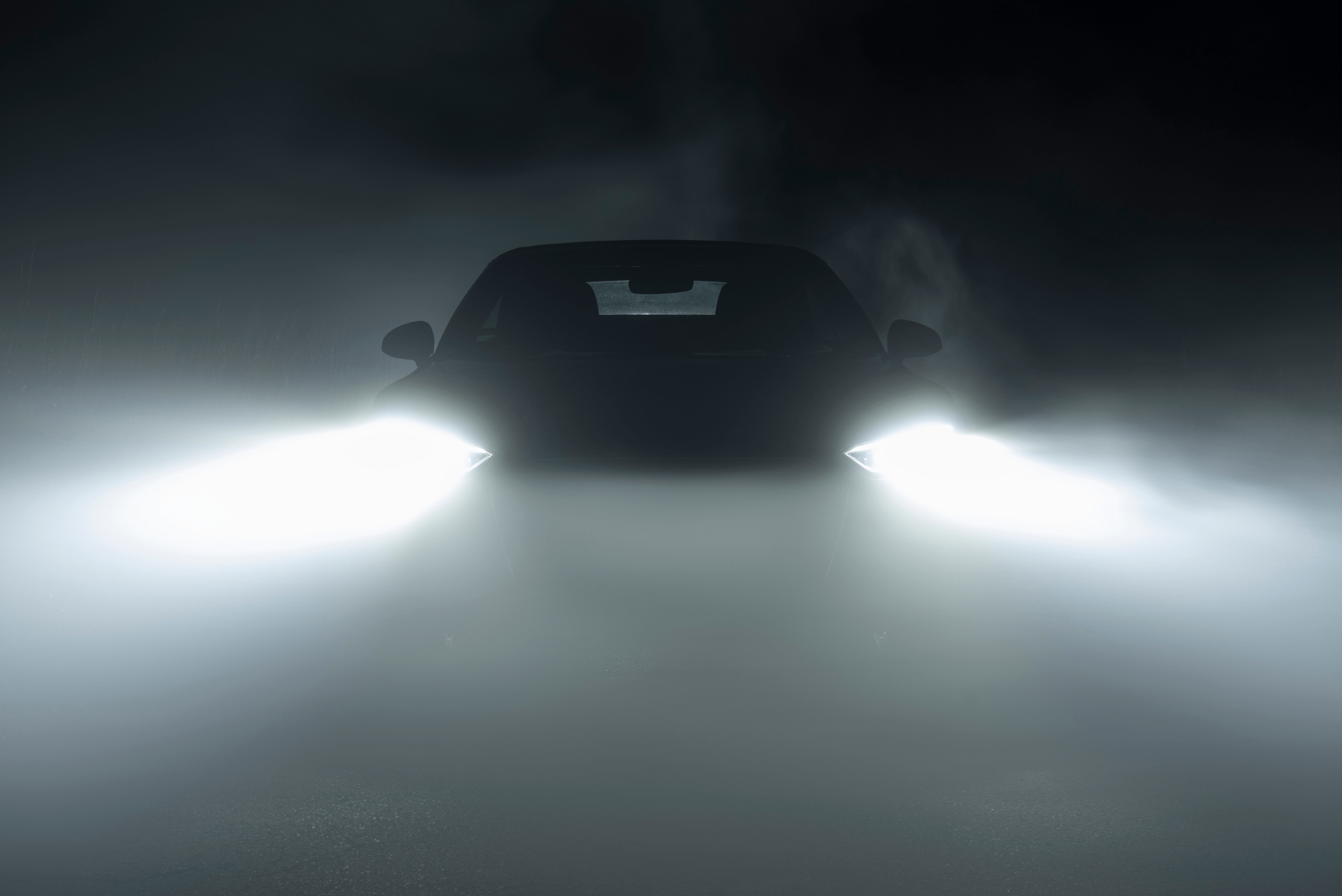 Vehicle with headlights on a hazy night.