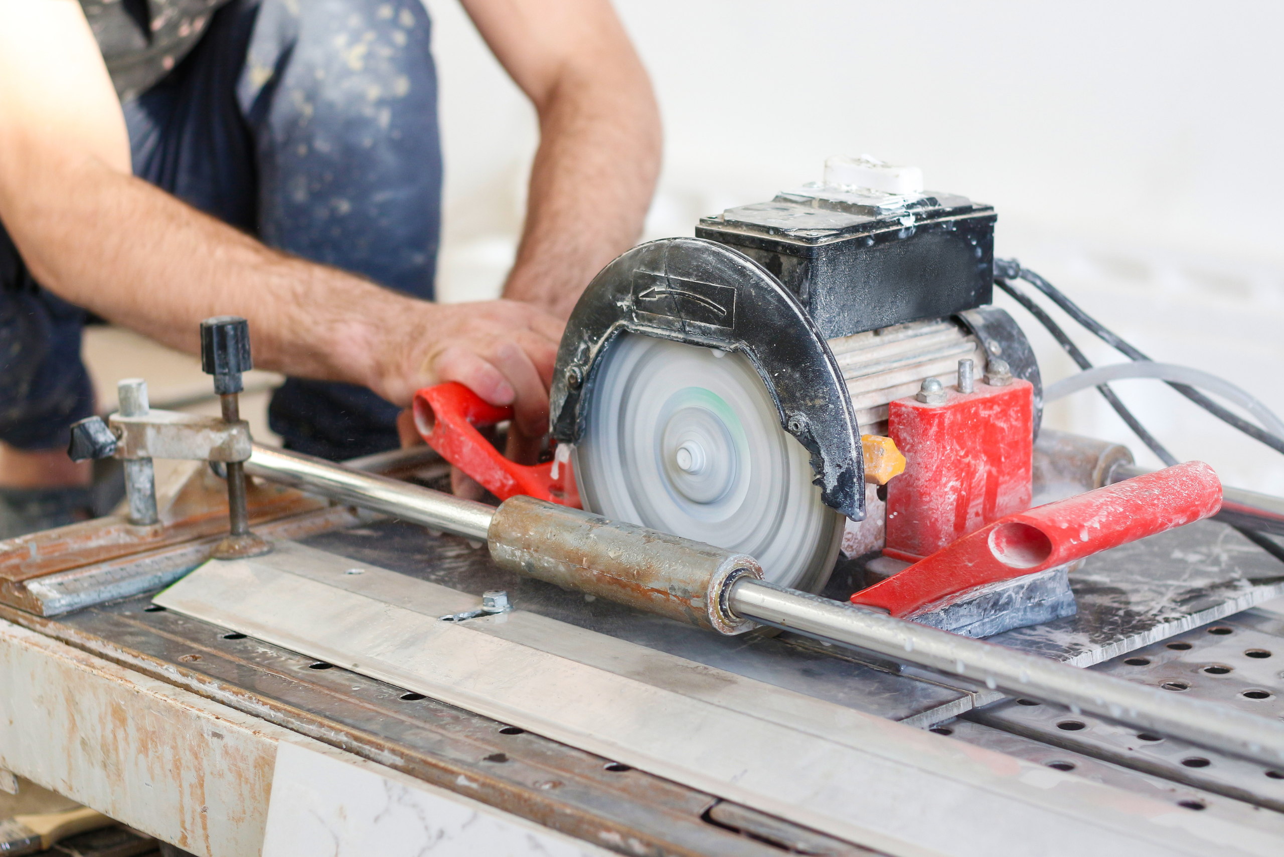 Electric saw cutting tile.