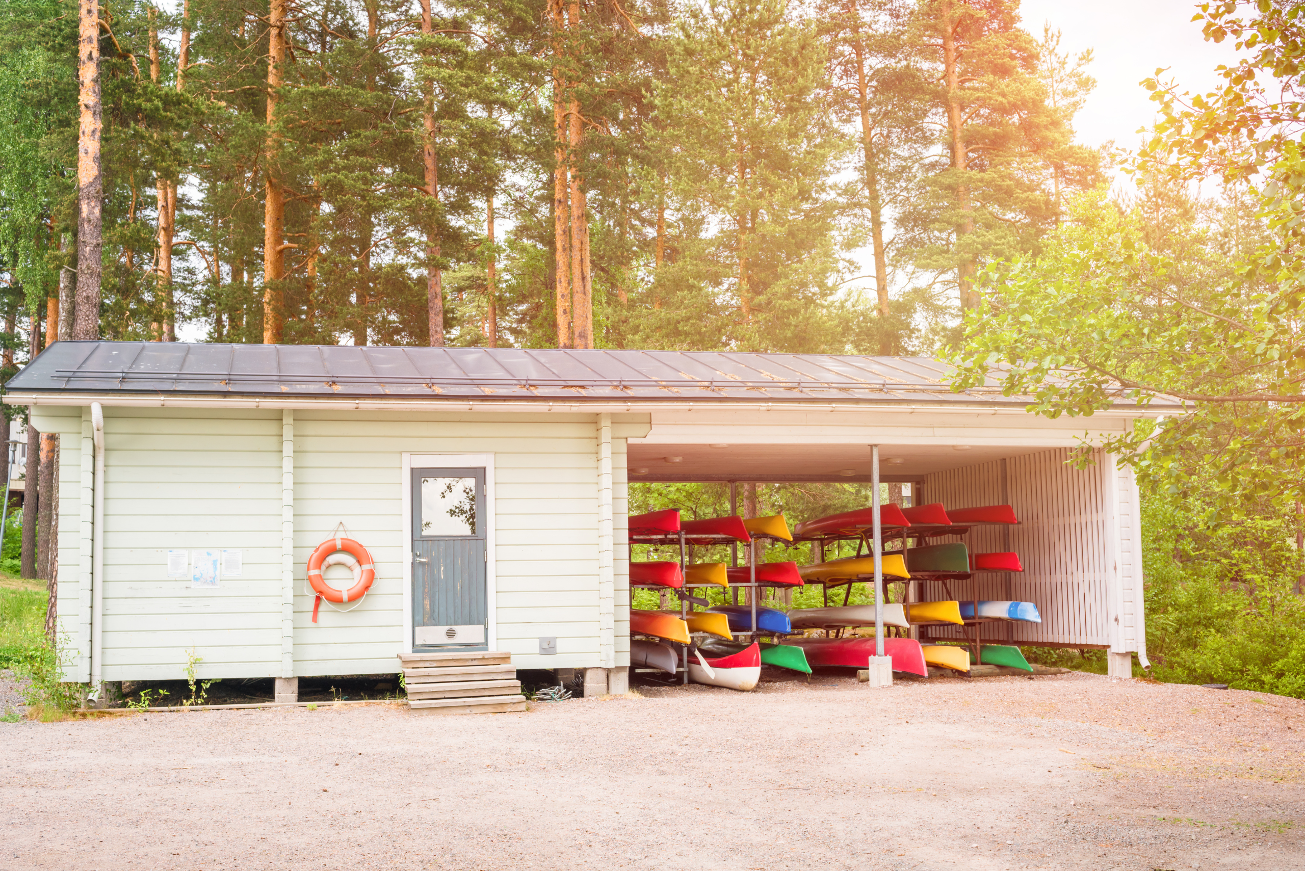 A building with a DIY kayak rack inside under an extension.