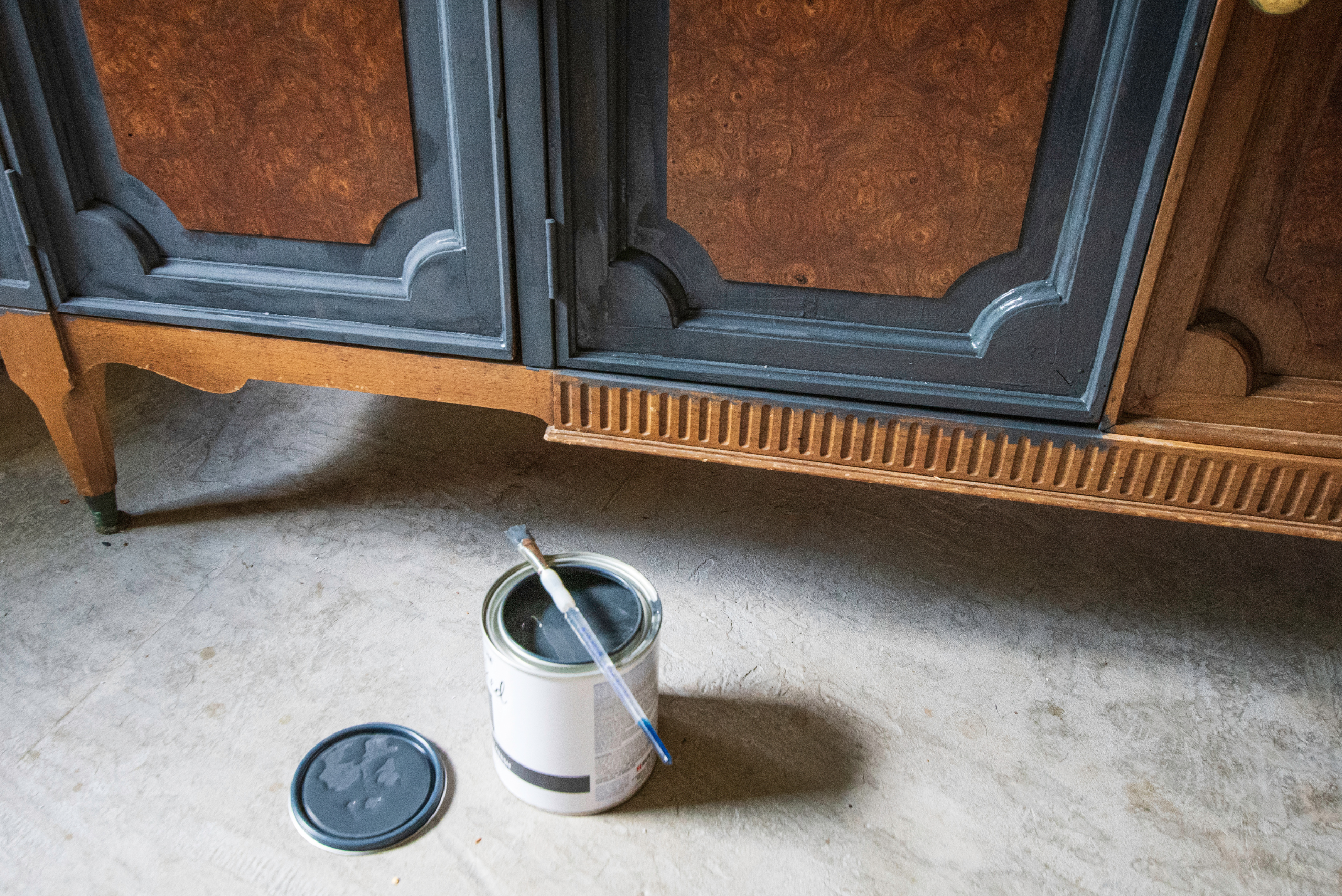 Painting stained wooden furniture with paintbrush.