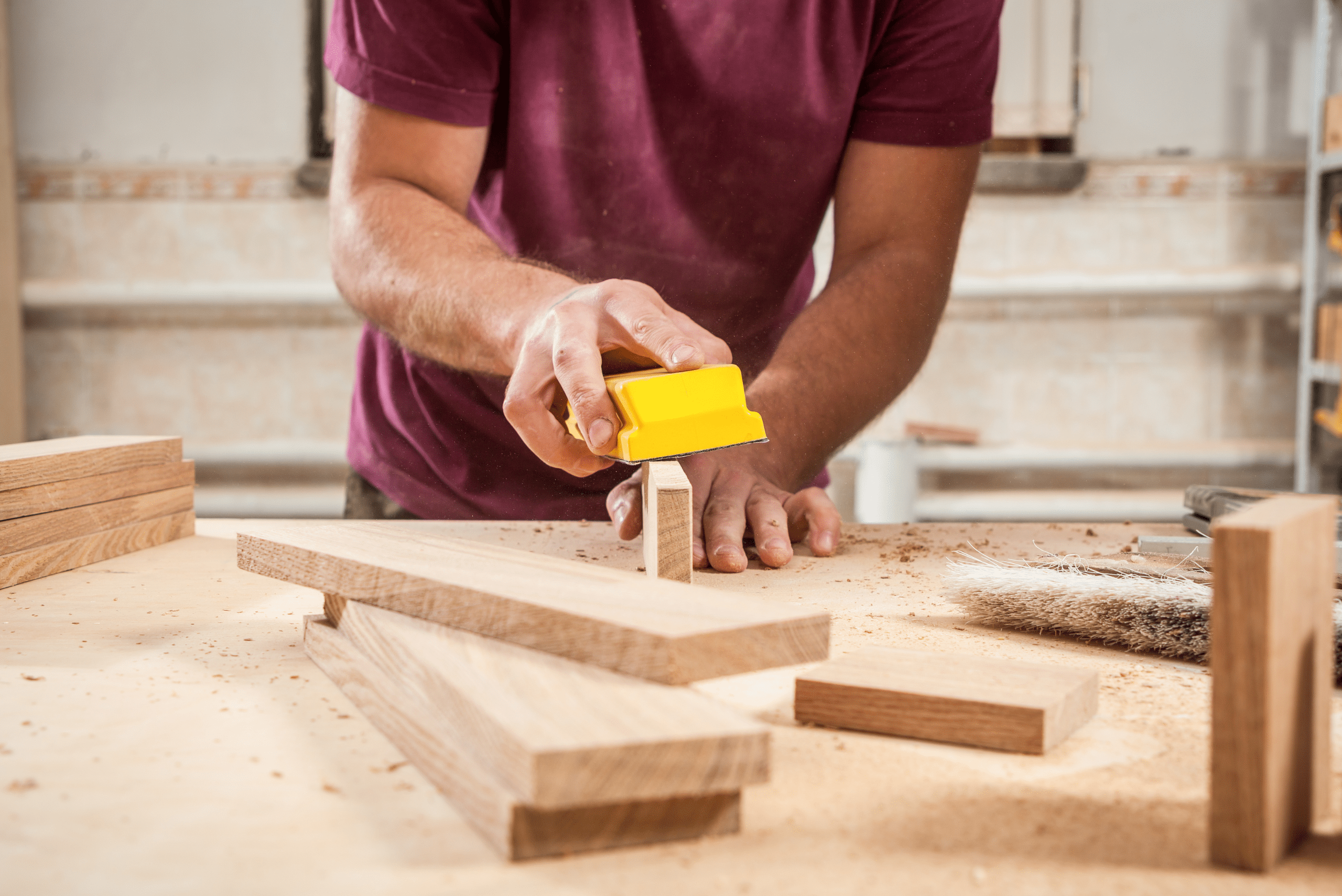 Closeup of someone sanding wooden boards.