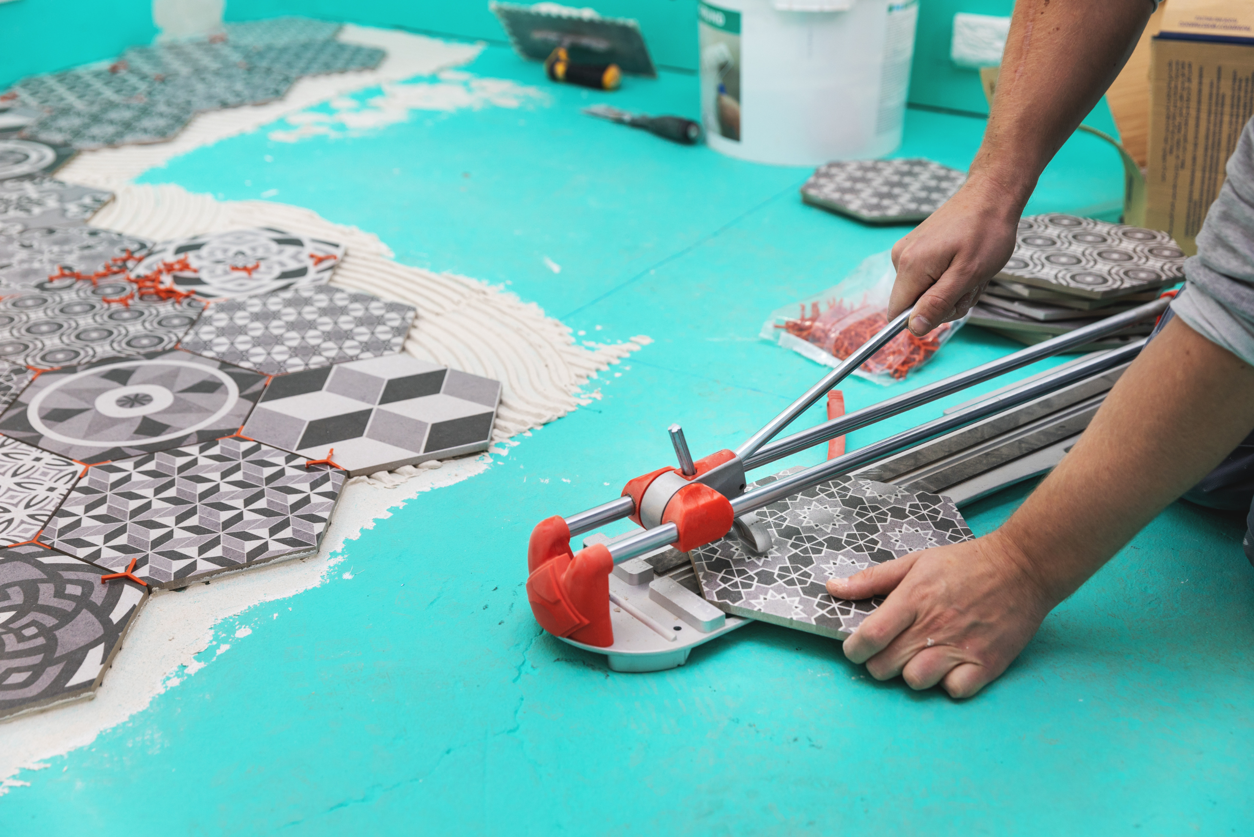 A person using a manual tile cutter.