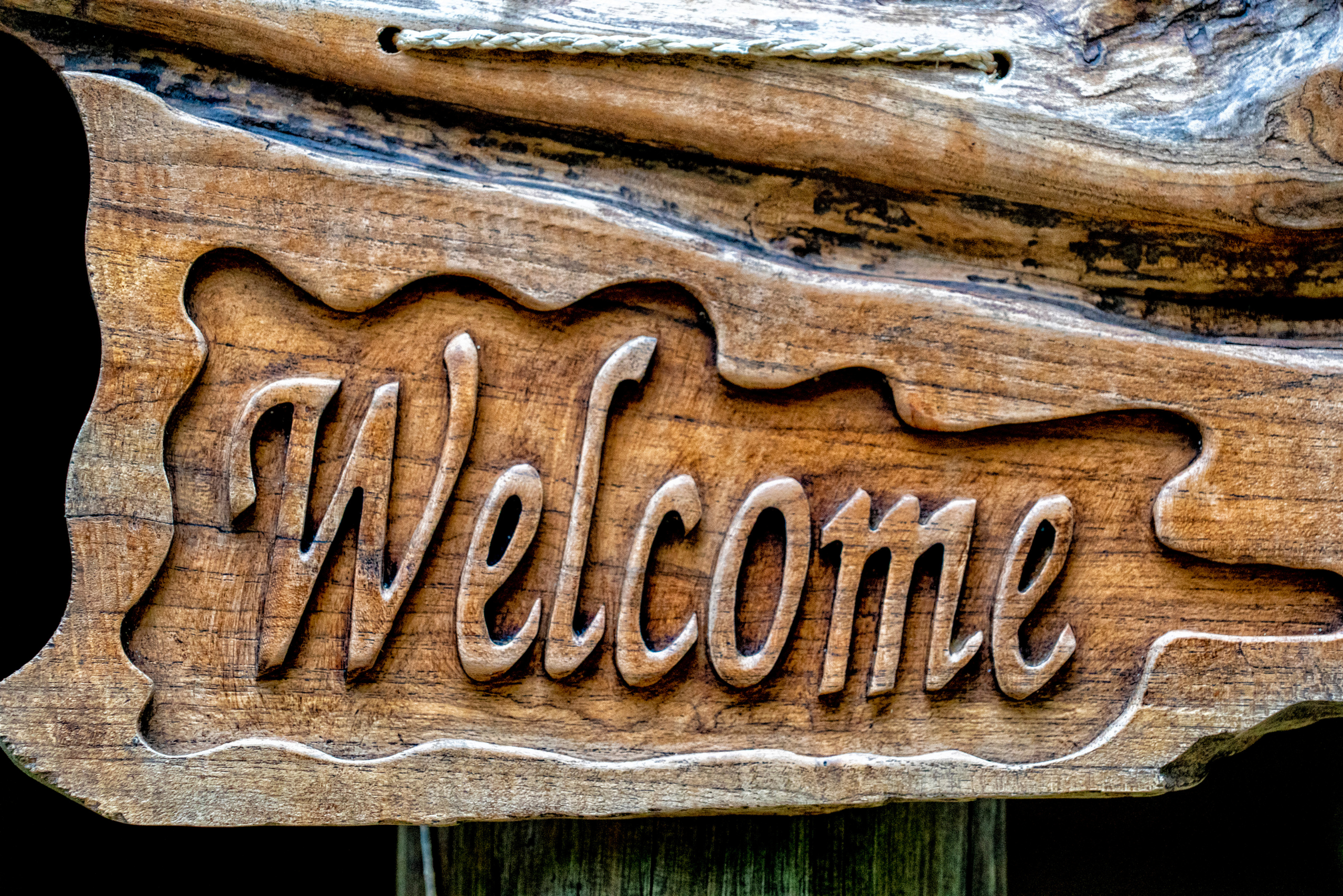 A "Welcome" sign carved of wood.