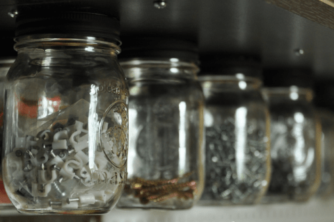 Various hardware stored in glass jars.