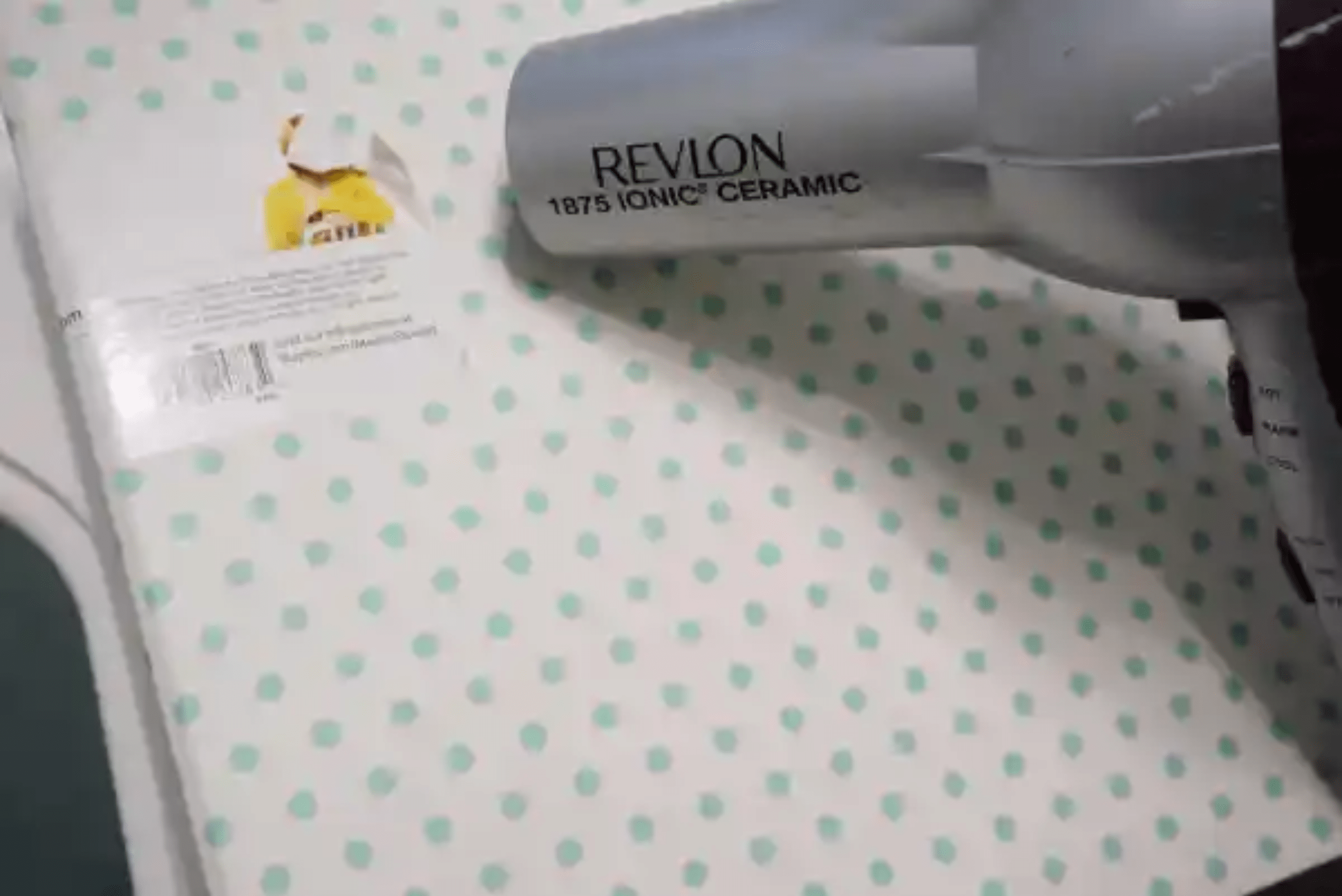 Hair dryer applying heat to sticker.
