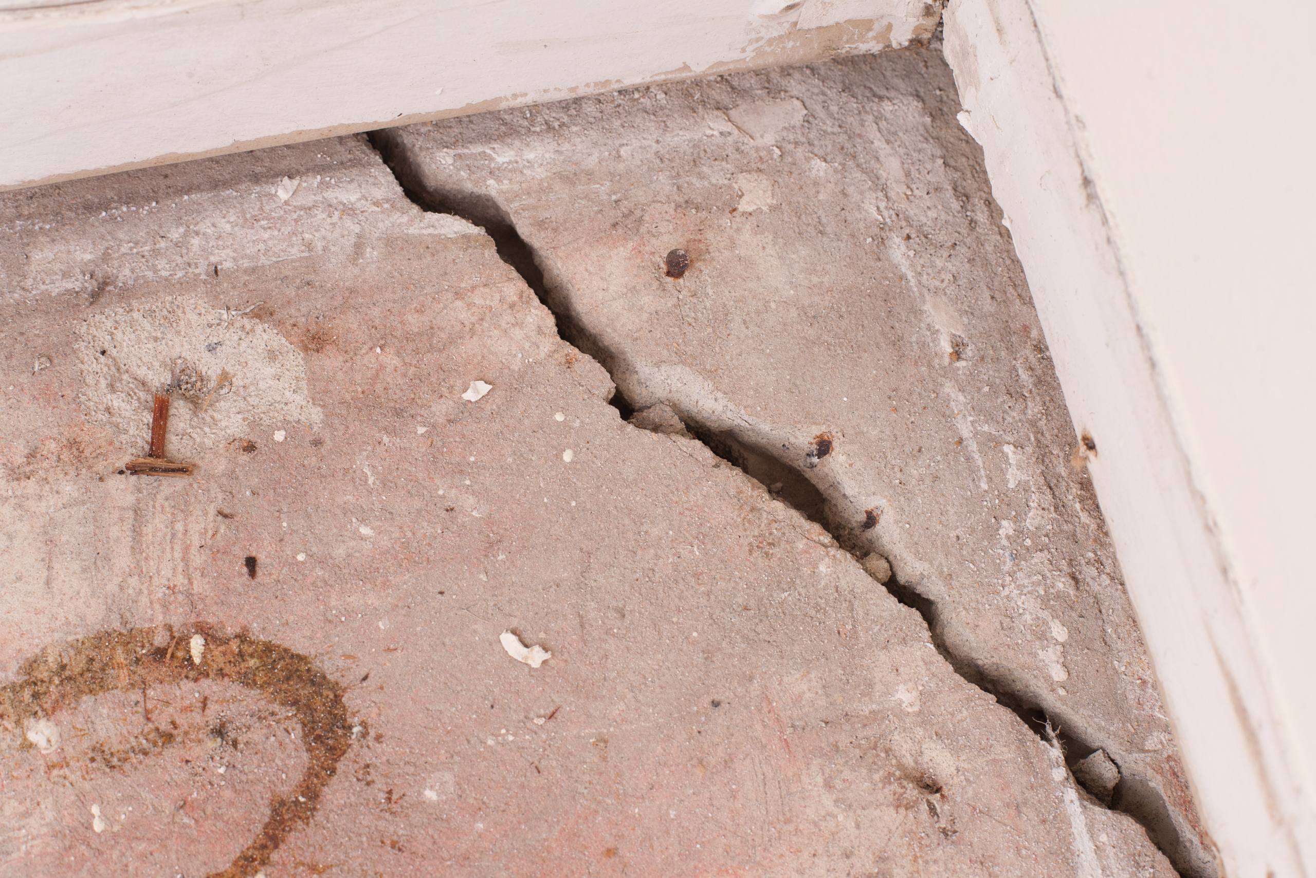 Massive cracking in a corner of a concrete floor.