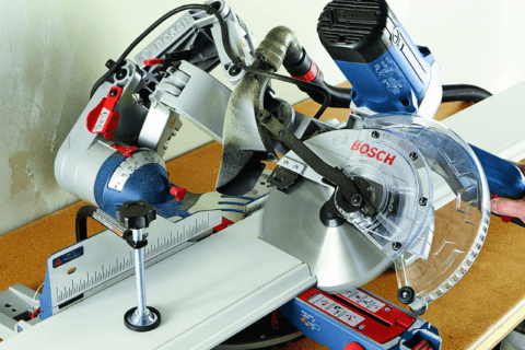 A double-bevel Bosch miter saw cutting on an angle.