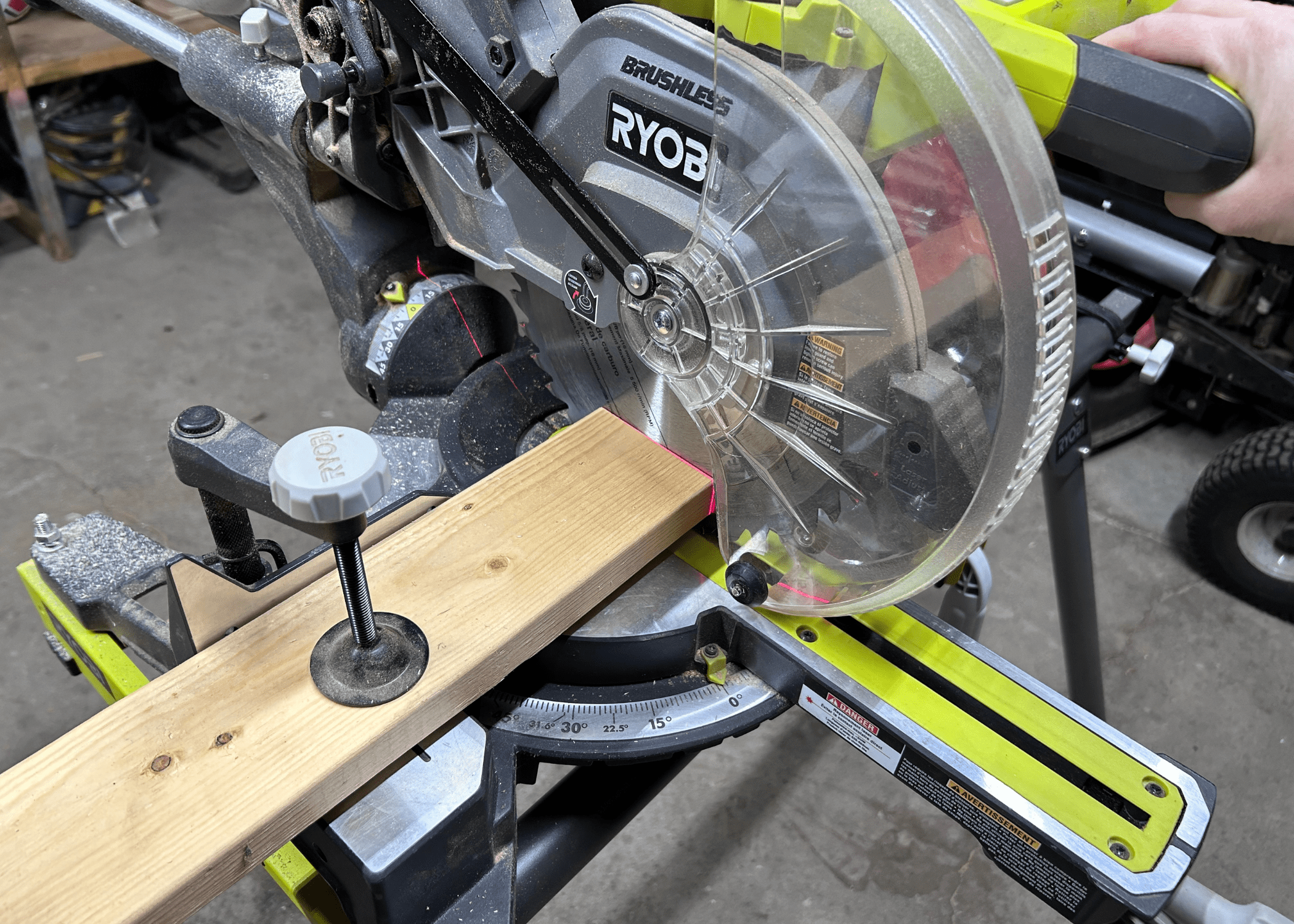 cutting through a piece of wood on a miter saw