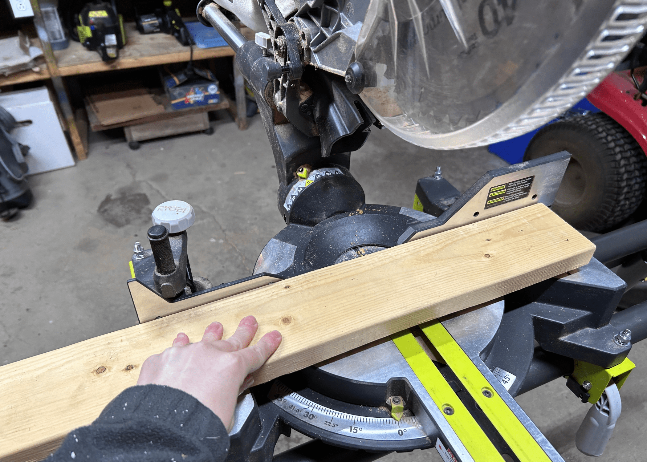 pushing wood against the fence of a miter saw