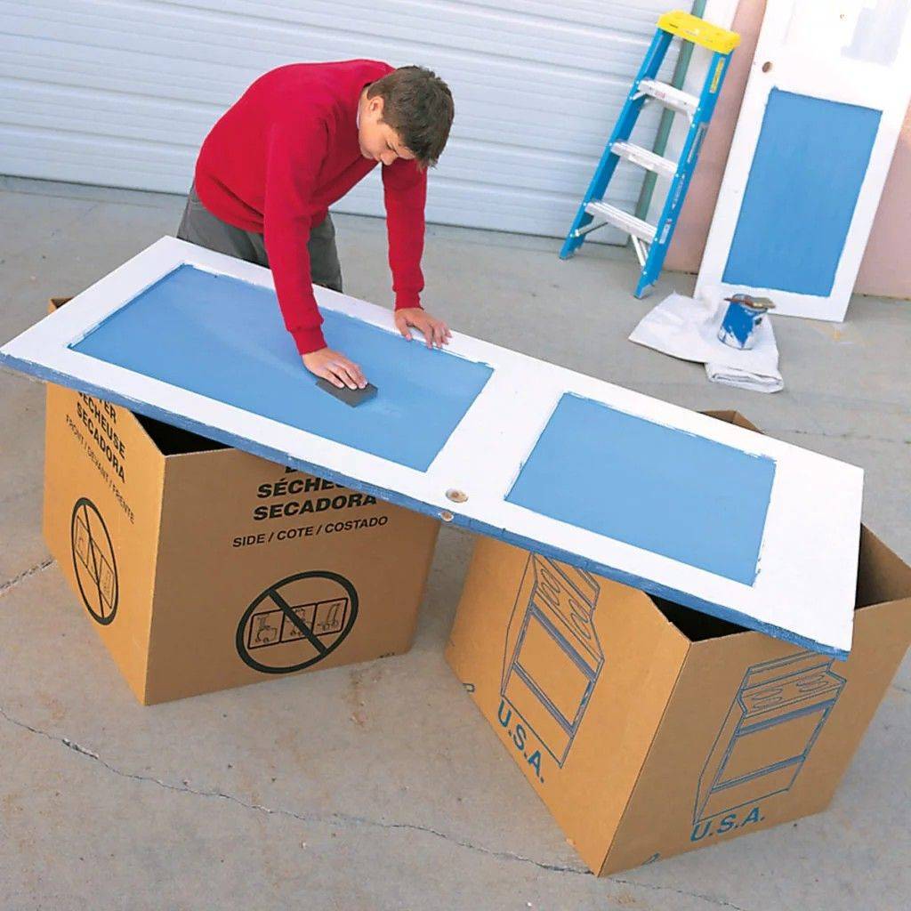 A person using cardboard boxes as sawhorses.