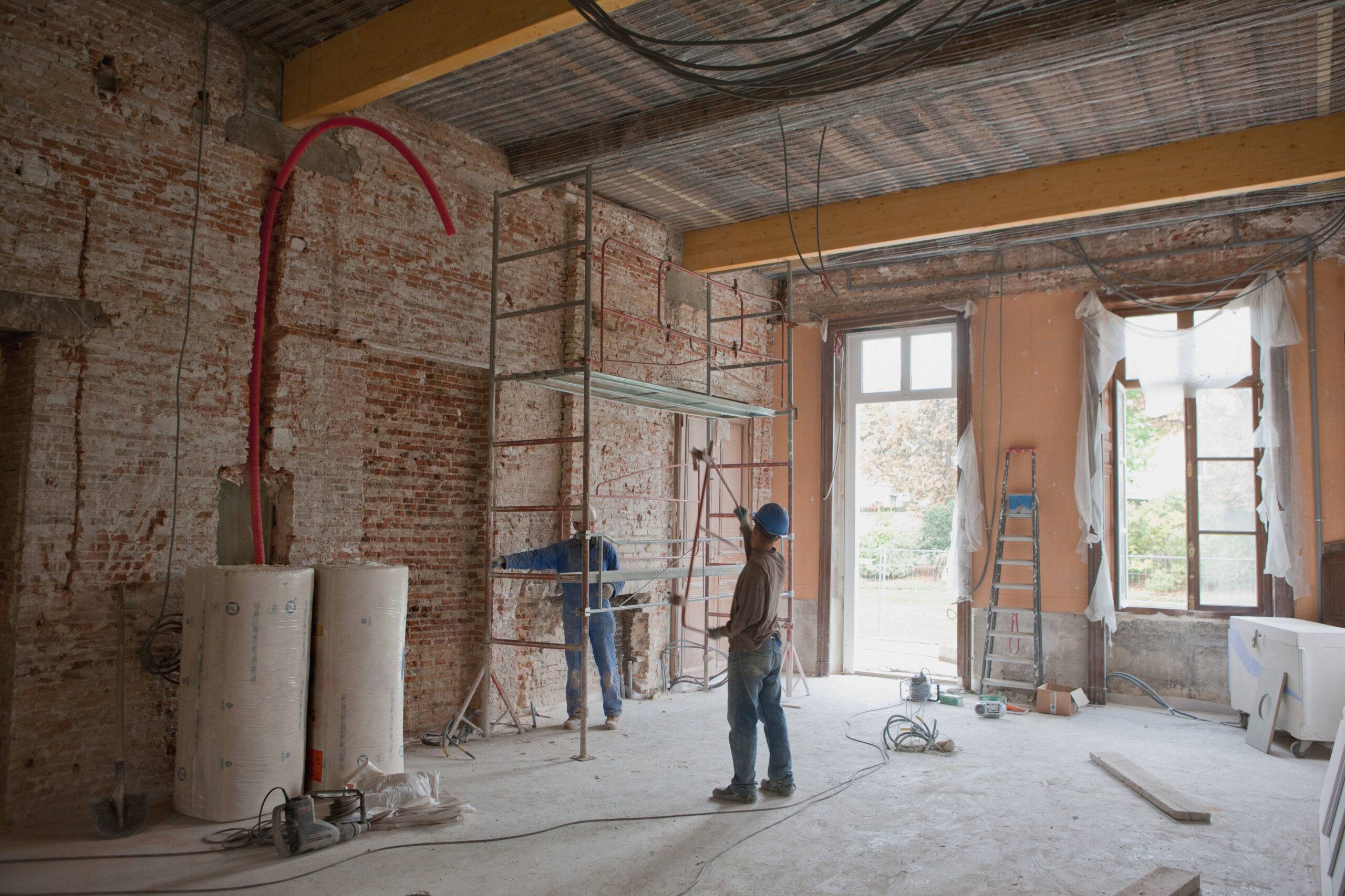 man standing in brick walled room with high ceilings that's under renovation