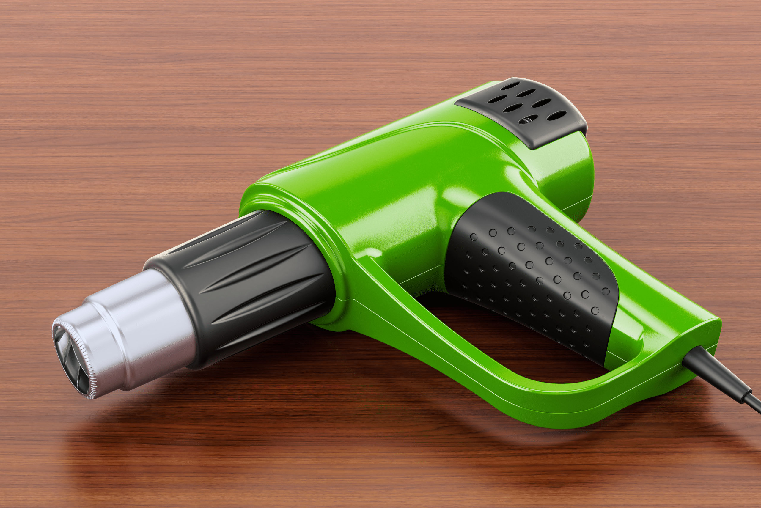 Green heat gun on a wooden board.