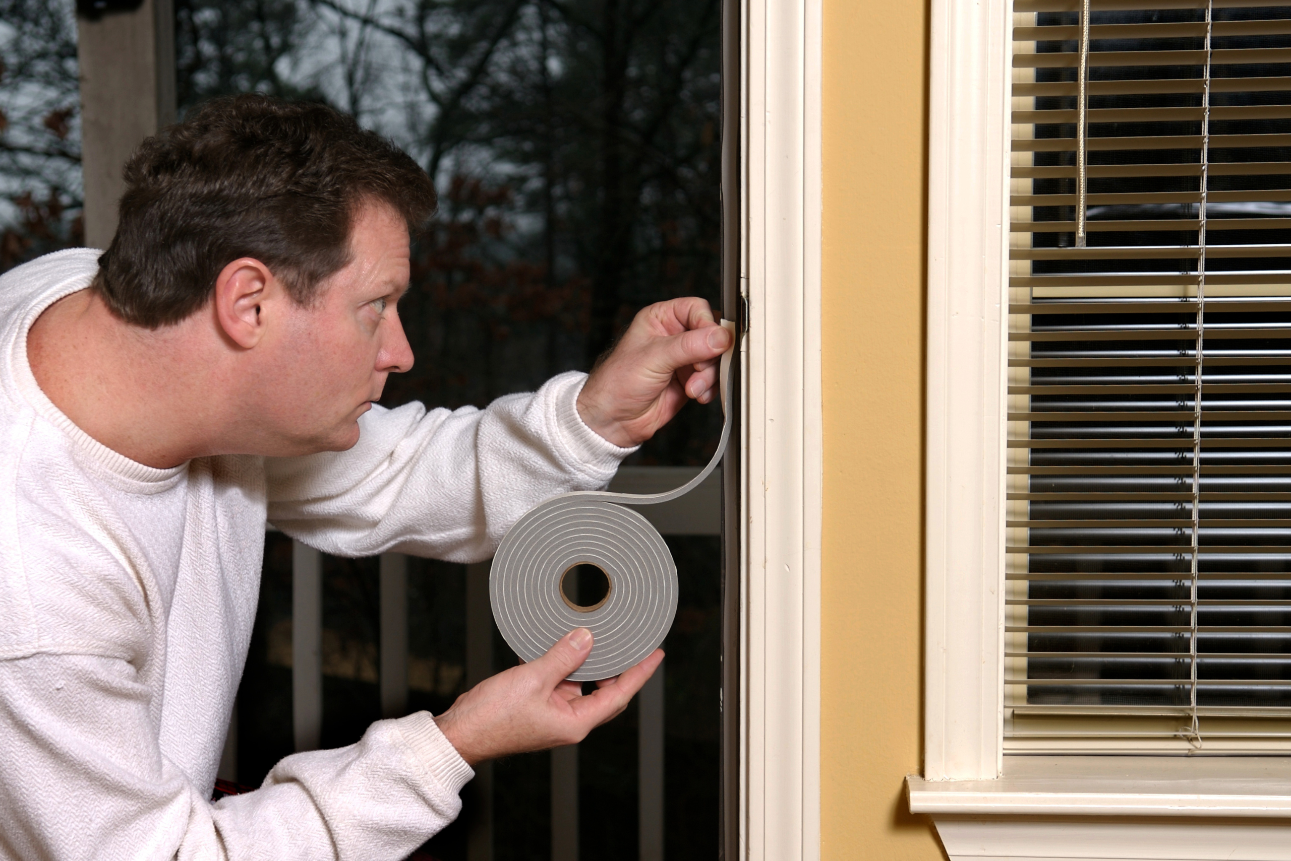 Person applying weather stripping to a door.