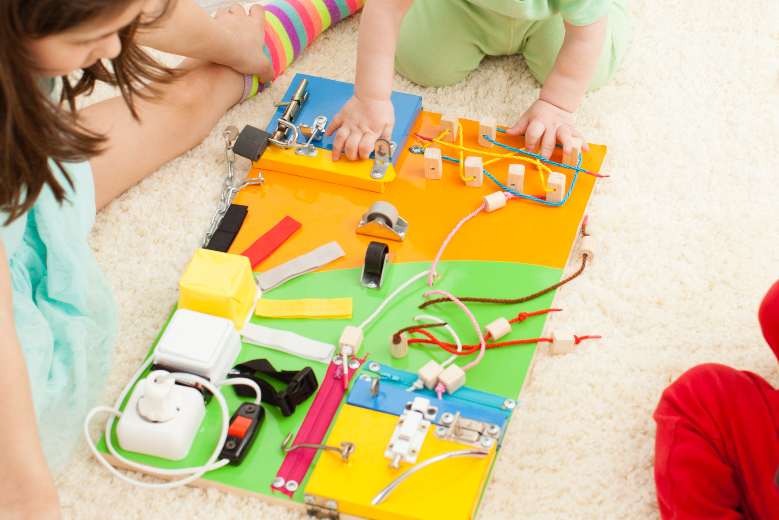 Kids playing with a DIY busy board.