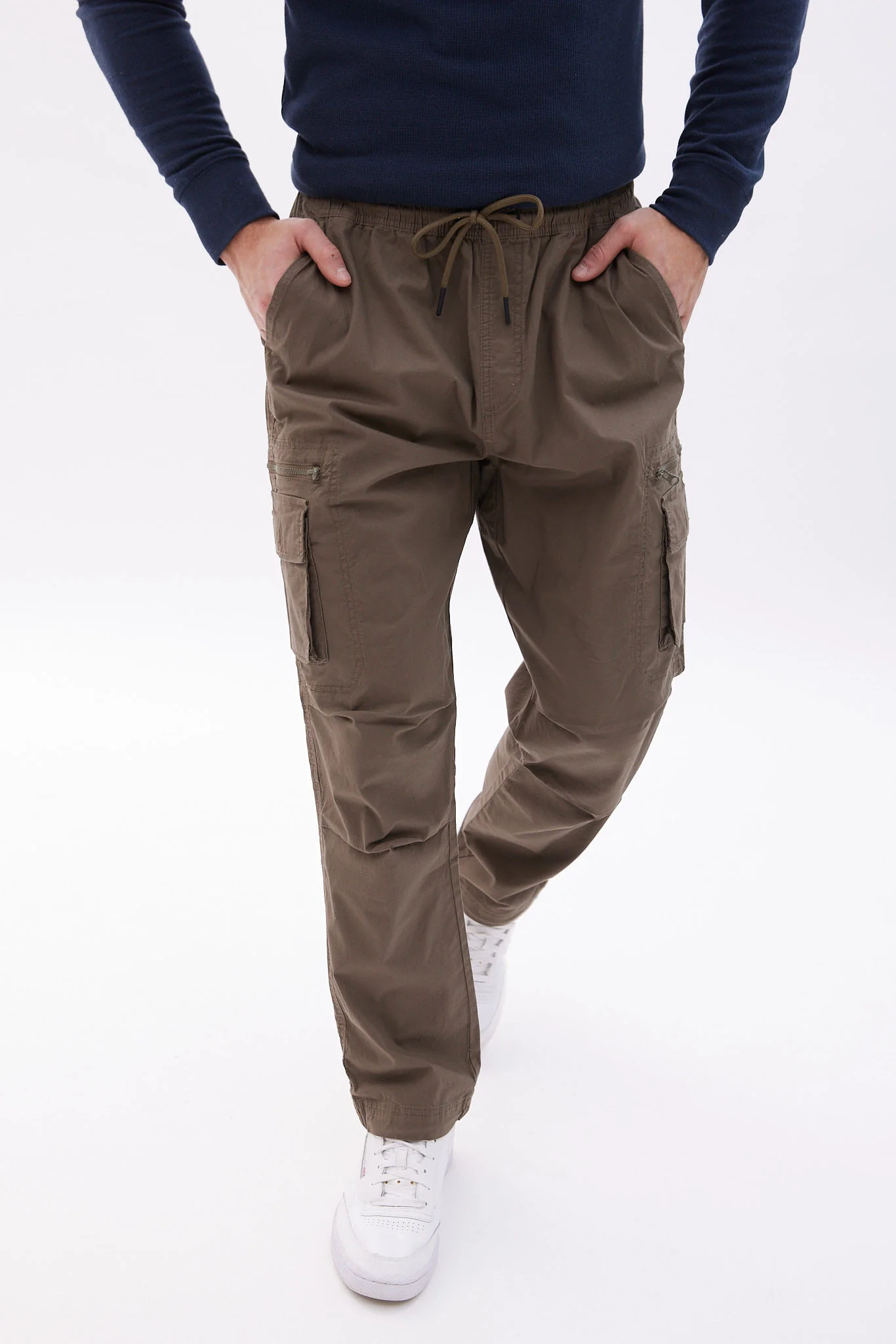 A man wearing modern cargo pants and white shoes.