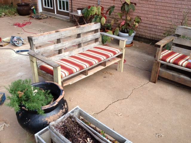 A DIY pallet outdoor bench with cushions.